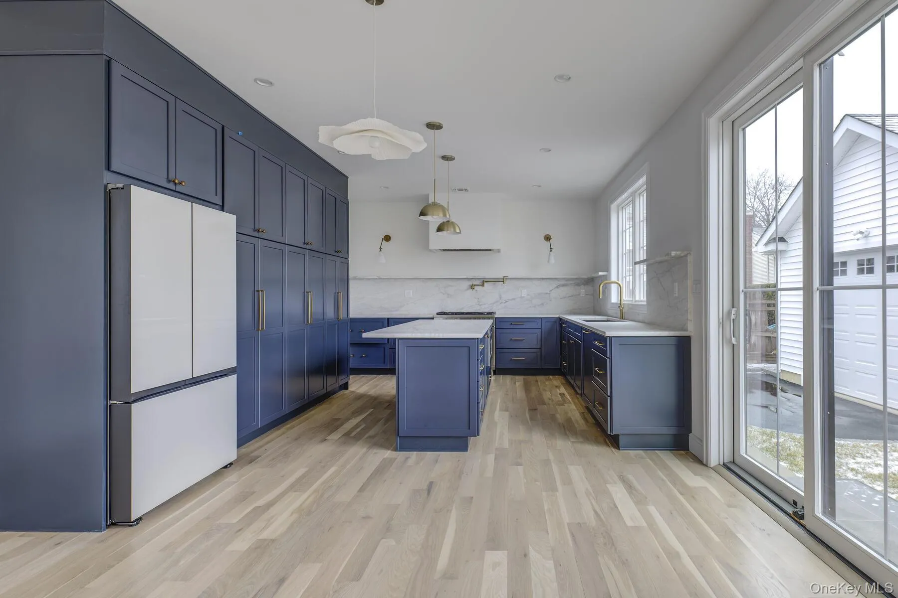Kitchen featuring a sink, light countertops, fridge, decorative backsplash, and a center island Kitchen featuring a sink, light countertops, fridge, decorative backsplash, and a center island