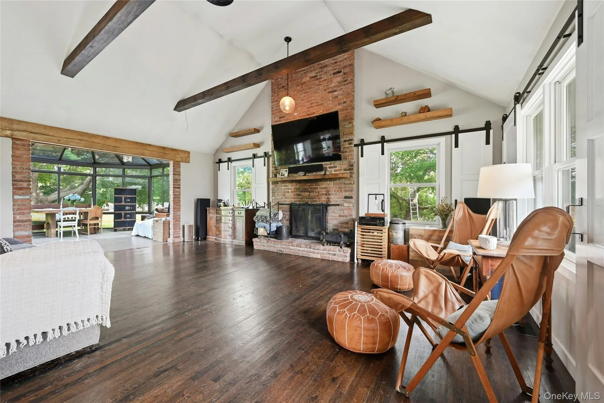 Living room with vaulted ceiling, wood burning fire place, free floating shelves, hardwood flooring Living room with vaulted ceiling, wood burning fire place, free floating shelves, hardwood flooring