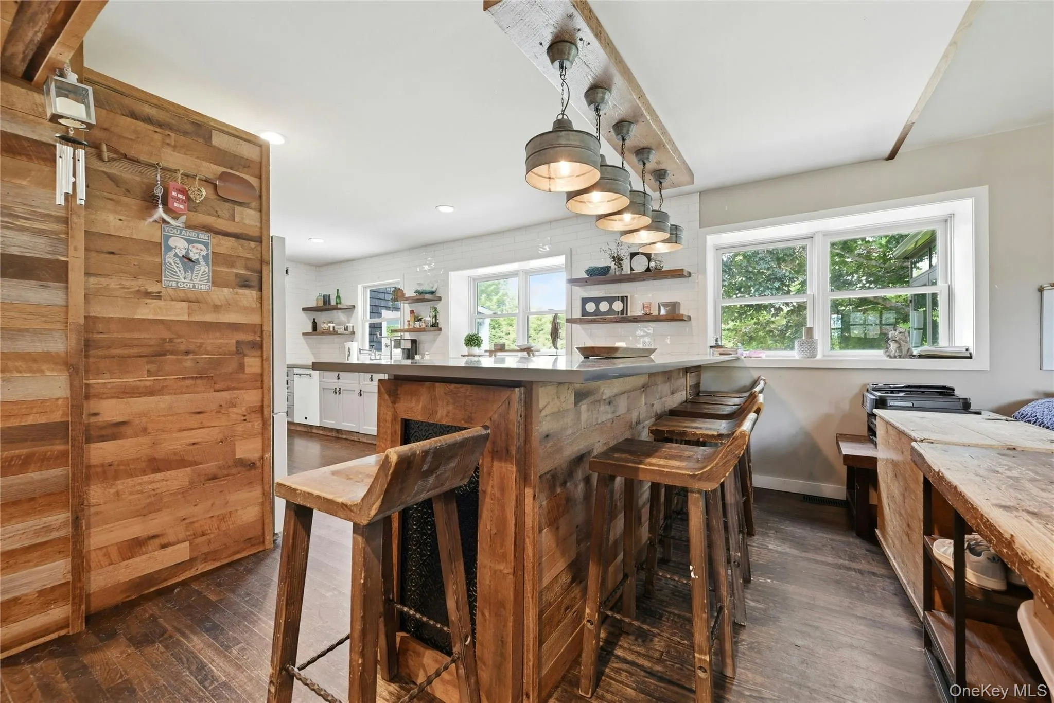 Rustic-inspired kitchen with a wood-clad breakfast bar and integrated barstools Rustic-inspired kitchen with a wood-clad breakfast bar and integrated barstools