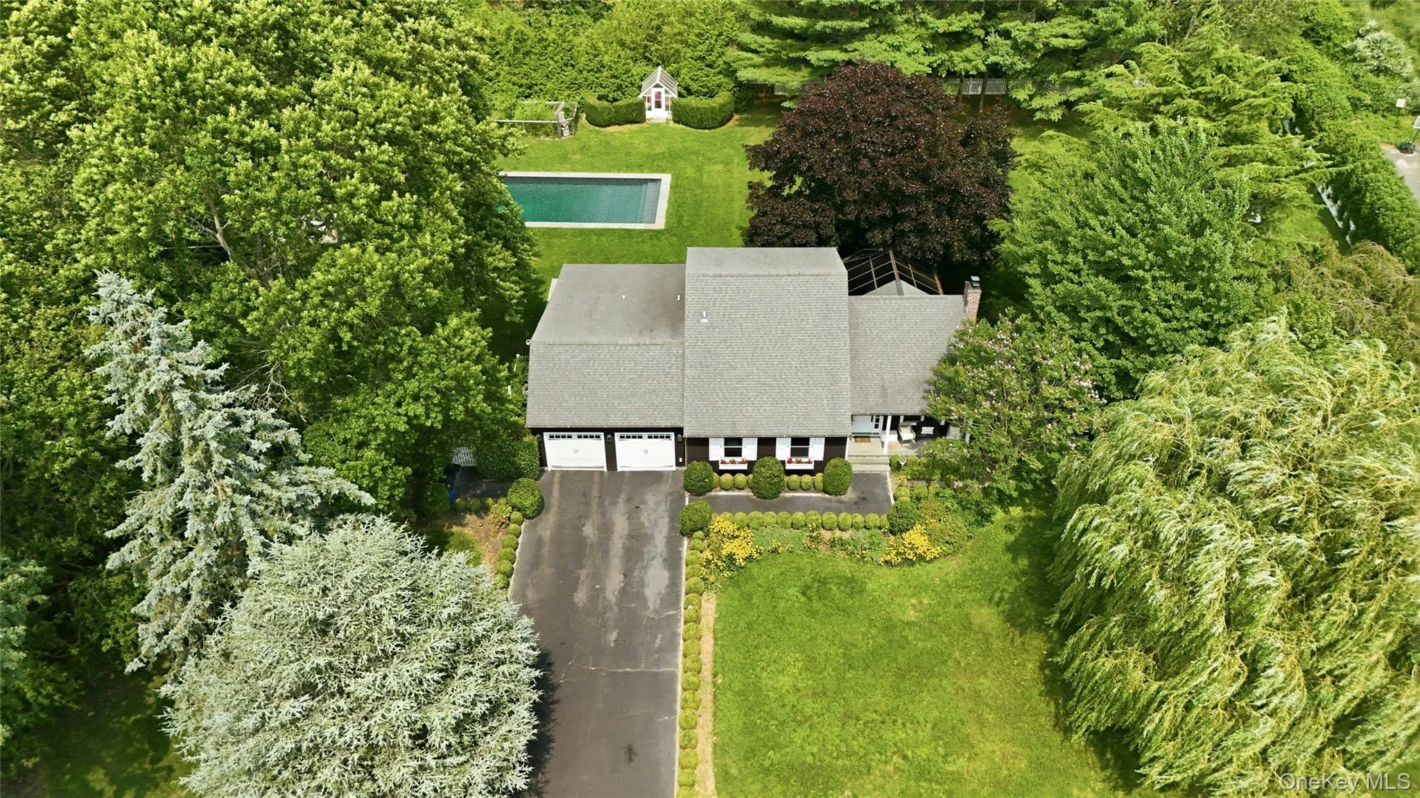 Ranch-style residence featuring a prominent two-car garage, asphalt driveway, and a shingle roof Ranch-style residence featuring a prominent two-car garage, asphalt driveway, and a shingle roof