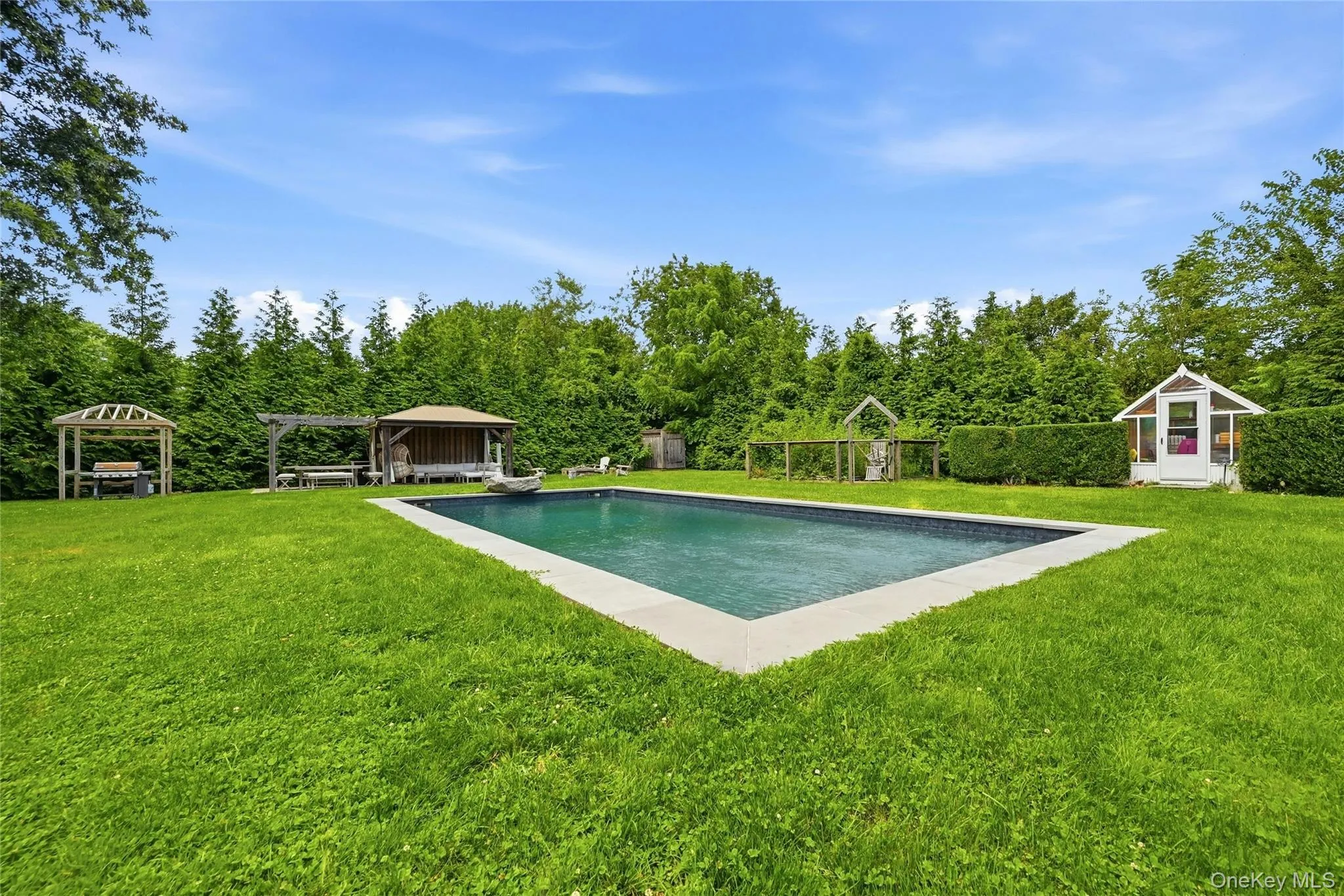 Rectangular inground salt water pool with stone coping, entertaining cabana in the back-ground Rectangular inground salt water pool with stone coping, entertaining cabana in the back-ground