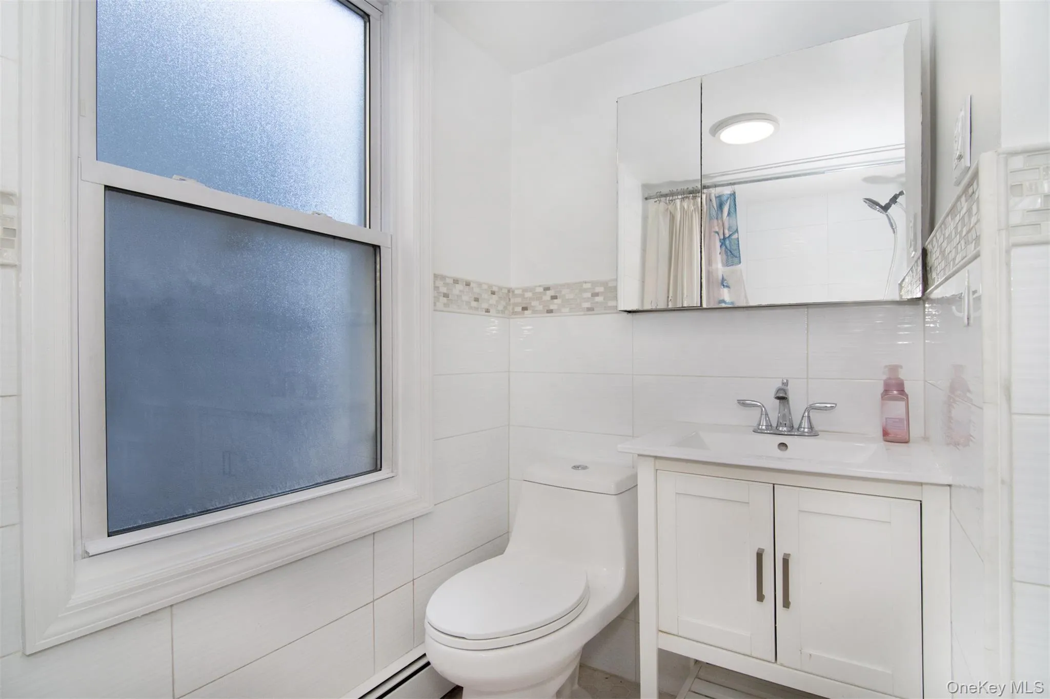 Bathroom featuring tile walls, toilet, walk in shower, decorative backsplash, and vanity Bathroom featuring tile walls, toilet, walk in shower, decorative backsplash, and vanity