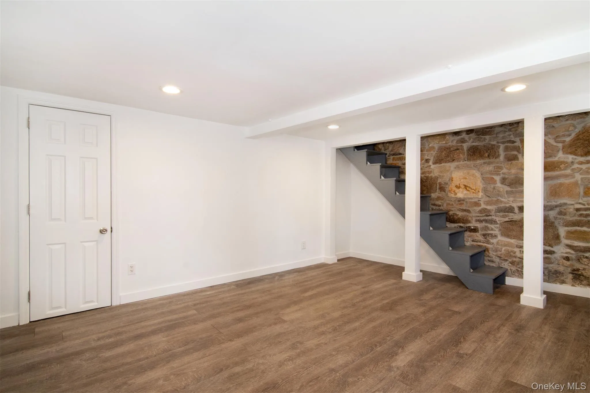Walkout Lower level featuring baseboard heating and dark hardwood / wood-style floors Walkout Lower level featuring baseboard heating and dark hardwood / wood-style floors