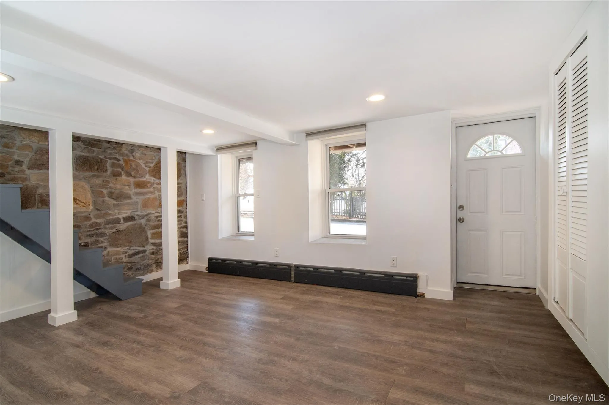Walkout Lower level featuring baseboard heating and dark hardwood / wood-style floors Walkout Lower level featuring baseboard heating and dark hardwood / wood-style floors