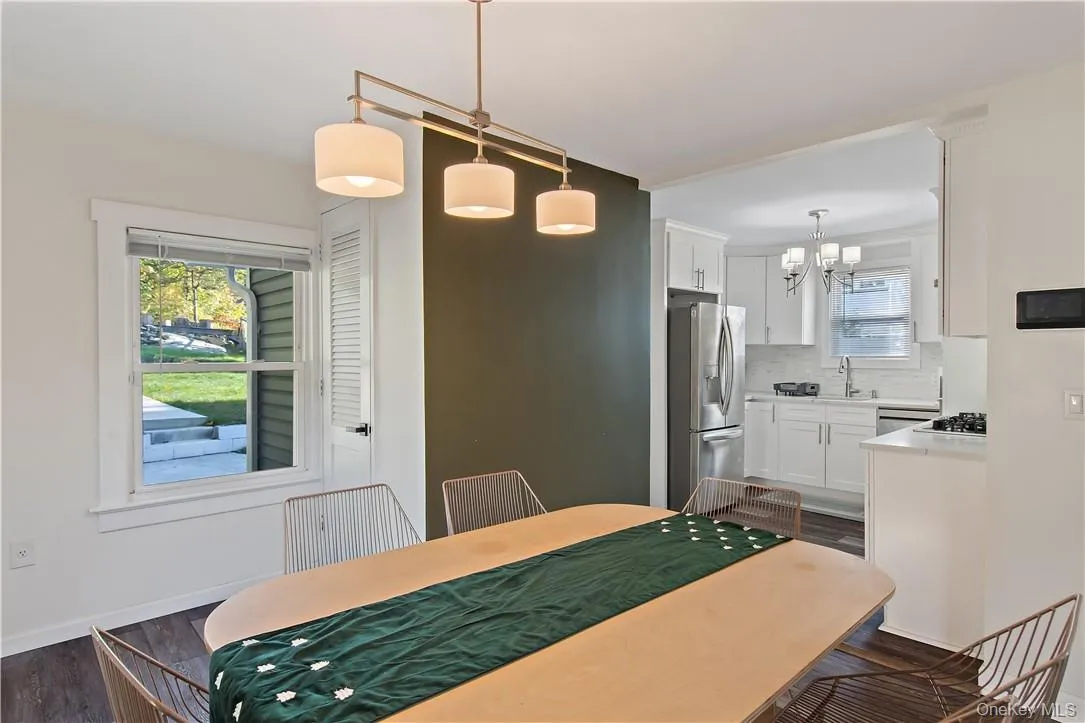 Dining area featuring dark wood-type flooring, a chandelier, and sink Dining area featuring dark wood-type flooring, a chandelier, and sink