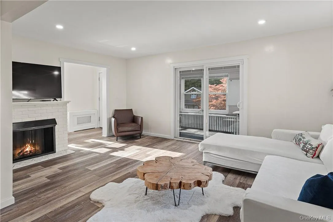 Living room featuring a brick fireplace and hardwood / wood-style flooring Living room featuring a brick fireplace and hardwood / wood-style flooring