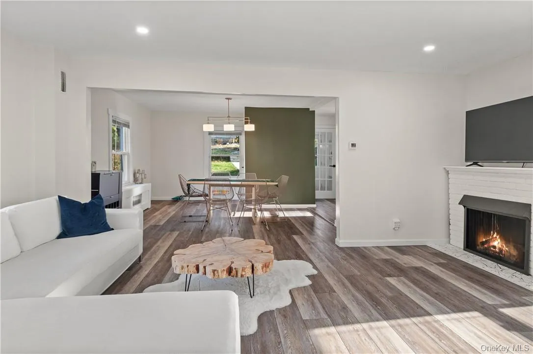 Living room featuring a brick fireplace and hardwood / wood-style flooring Living room featuring a brick fireplace and hardwood / wood-style flooring
