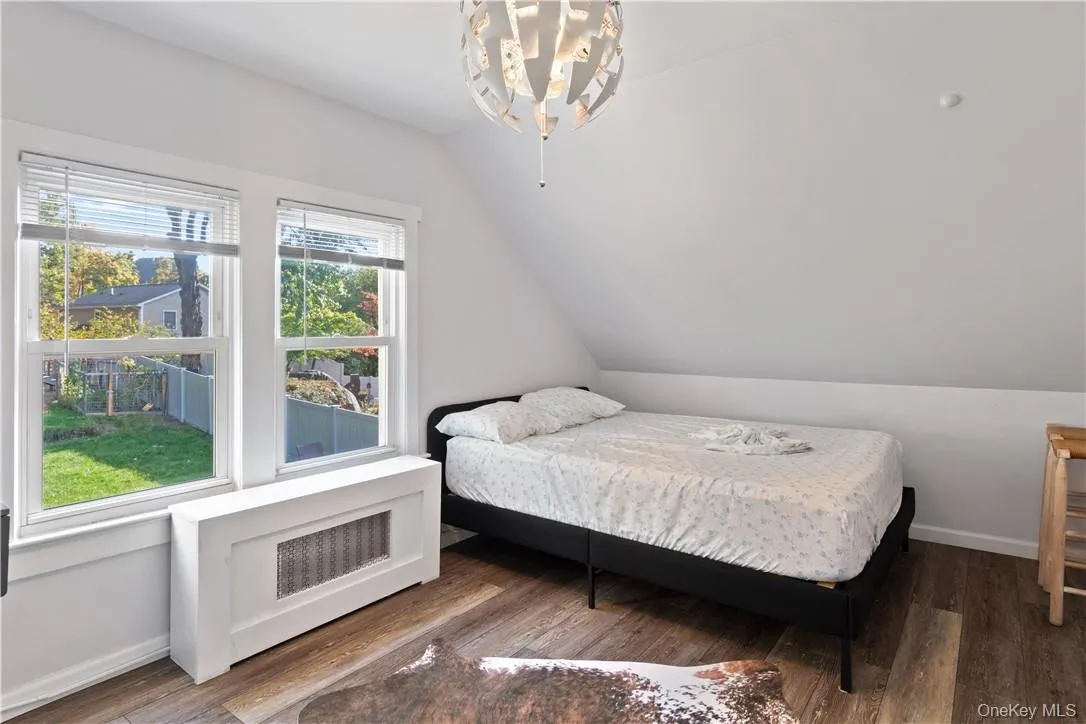 Bedroom featuring vaulted ceiling and wood-type flooring Bedroom featuring vaulted ceiling and wood-type flooring