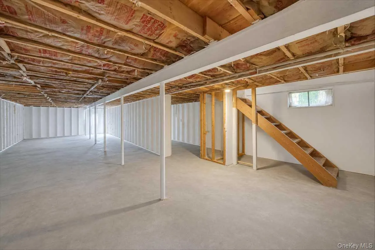 Expansive unfinished lower level featuring exposed ceiling joists, insulation, and support beams Expansive unfinished lower level featuring exposed ceiling joists, insulation, and support beams
