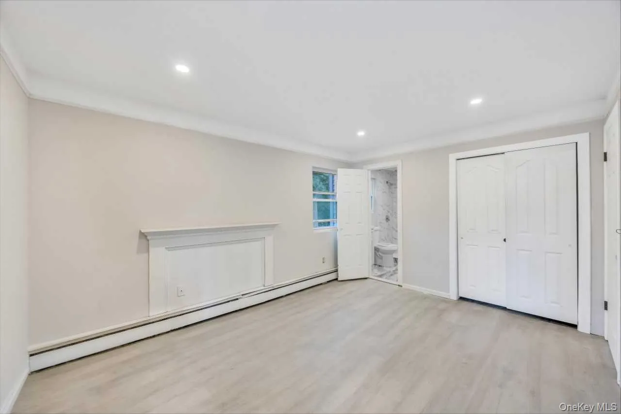 Spacious room featuring wood-finish flooring, recessed lighting, and crown molding Spacious room featuring wood-finish flooring, recessed lighting, and crown molding