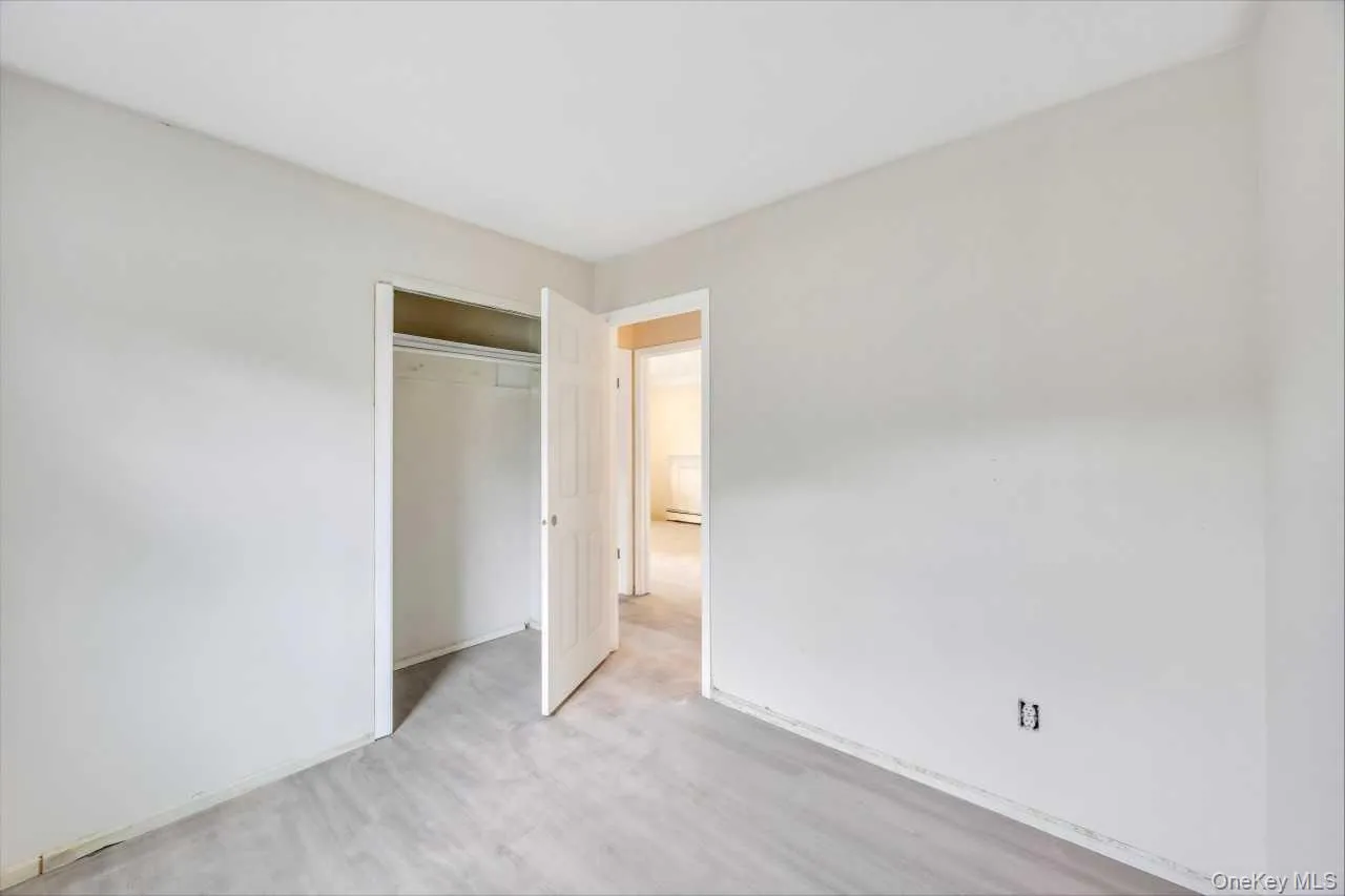 Room featuring light-toned walls, a white ceiling, and a closet with a white door and interior shelving Room featuring light-toned walls, a white ceiling, and a closet with a white door and interior shelving