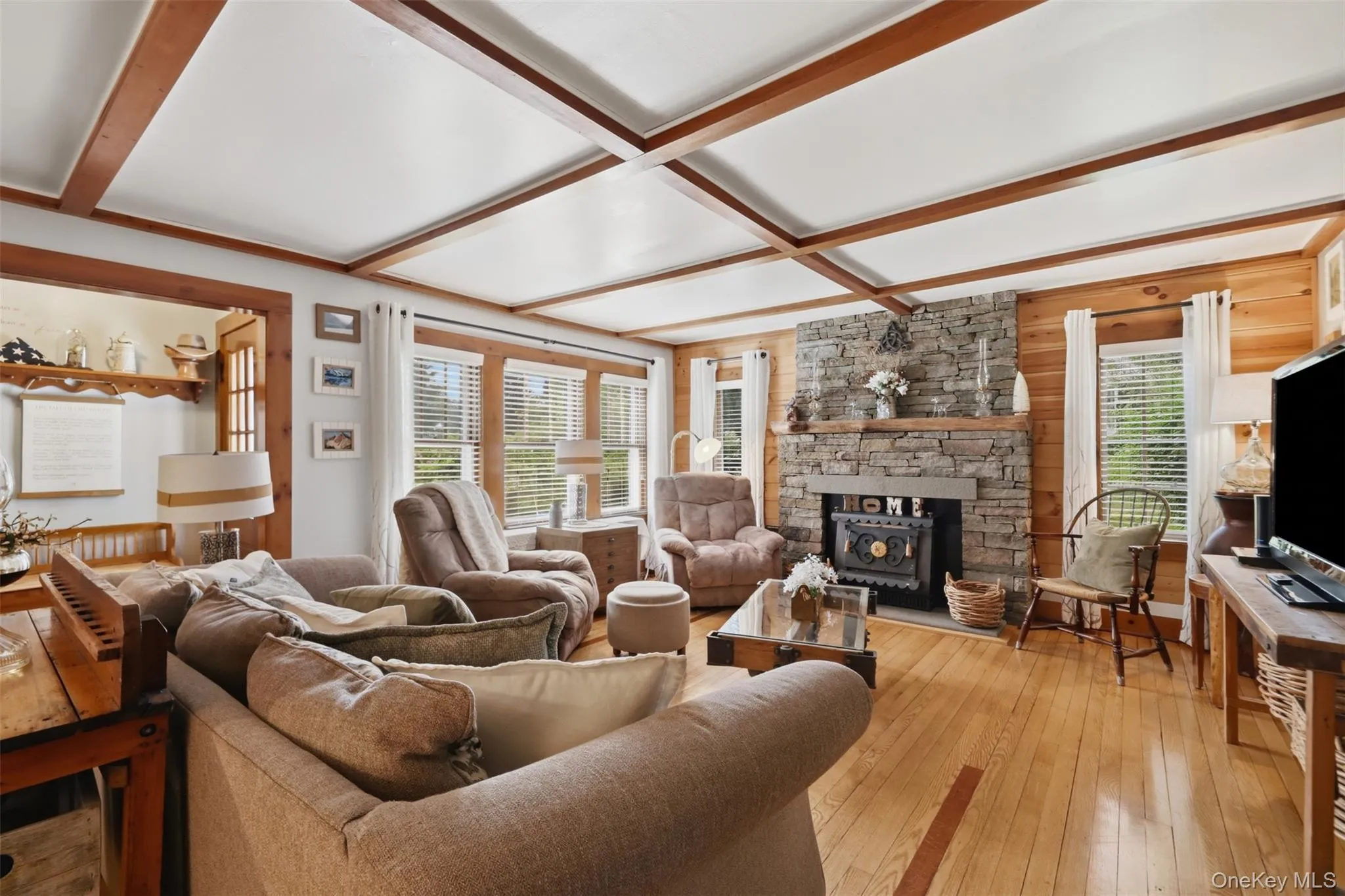 Hardwood floors, wood detail on the ceiling, handsome stone fireplace with woodstove insert. Hardwood floors, wood detail on the ceiling, handsome stone fireplace with woodstove insert.