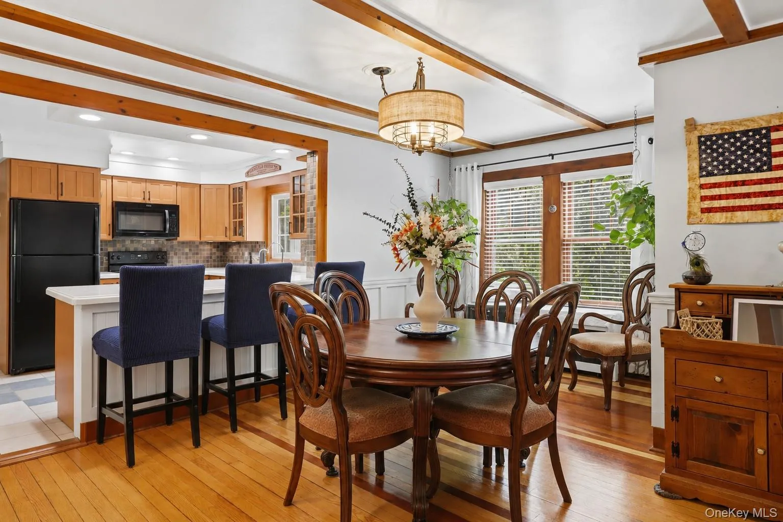 Cozy farmhouse dining and kitchen space with warm and inviting hardwood floors, wood details and large windows. Cozy farmhouse dining and kitchen space with warm and inviting hardwood floors, wood details and large windows.