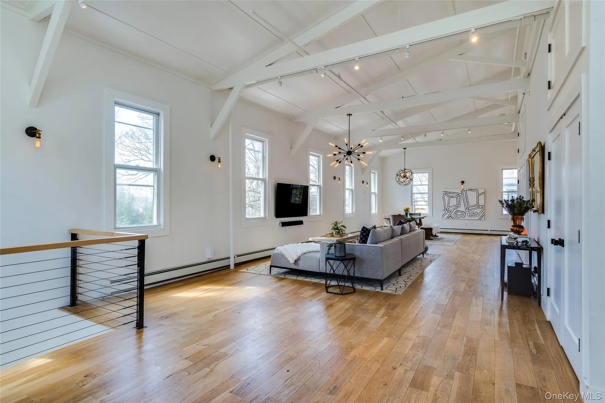 UpperExpansive open-concept room featuring high vaulted ceilings with exposed beams and recessed lighting UpperExpansive open-concept room featuring high vaulted ceilings with exposed beams and recessed lighting