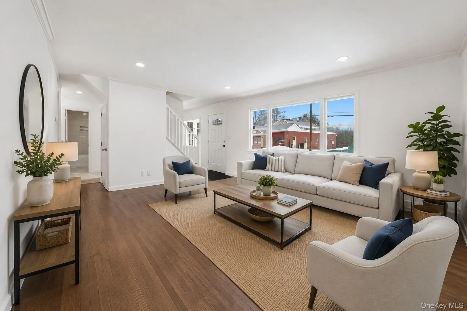 Bright living area featuring wood-finish flooring, white walls, and recessed lighting Bright living area featuring wood-finish flooring, white walls, and recessed lighting
