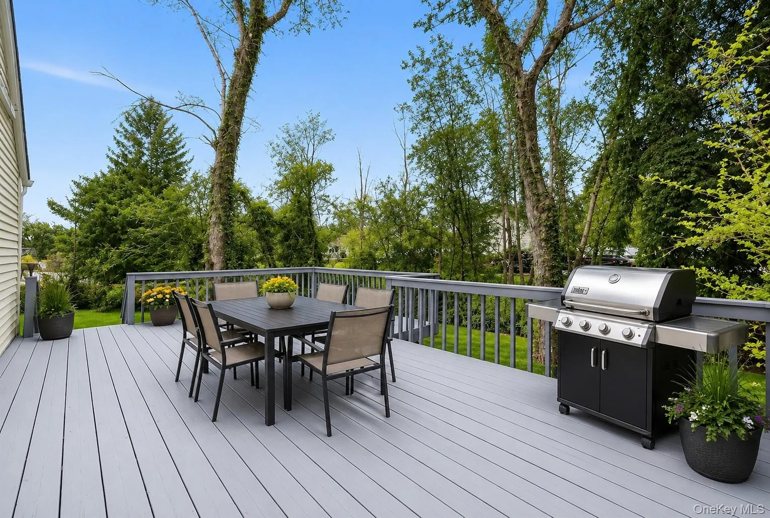 Spacious outdoor deck featuring light gray composite decking and matching railings Spacious outdoor deck featuring light gray composite decking and matching railings