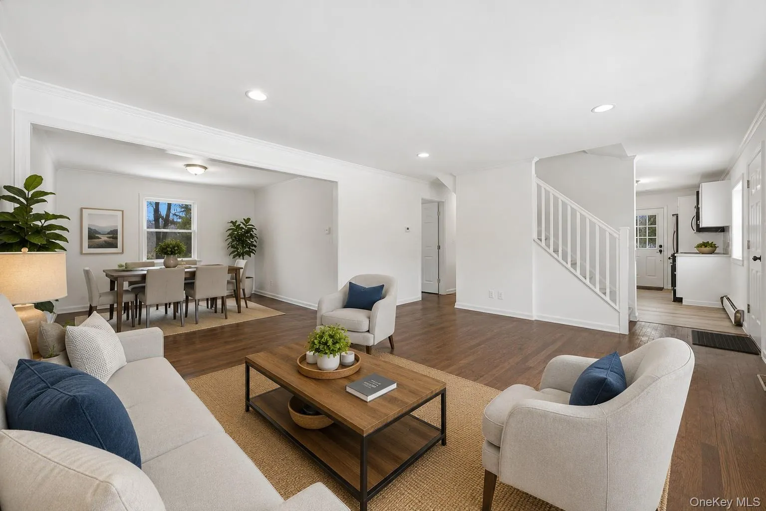 Open-concept living area with wood-finish flooring, recessed lighting, and white trim Open-concept living area with wood-finish flooring, recessed lighting, and white trim