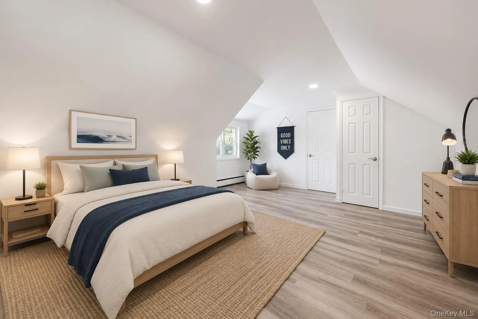 Bright room featuring sloped ceilings, recessed lighting, wood-finish flooring, two paneled doors, and a window Bright room featuring sloped ceilings, recessed lighting, wood-finish flooring, two paneled doors, and a window