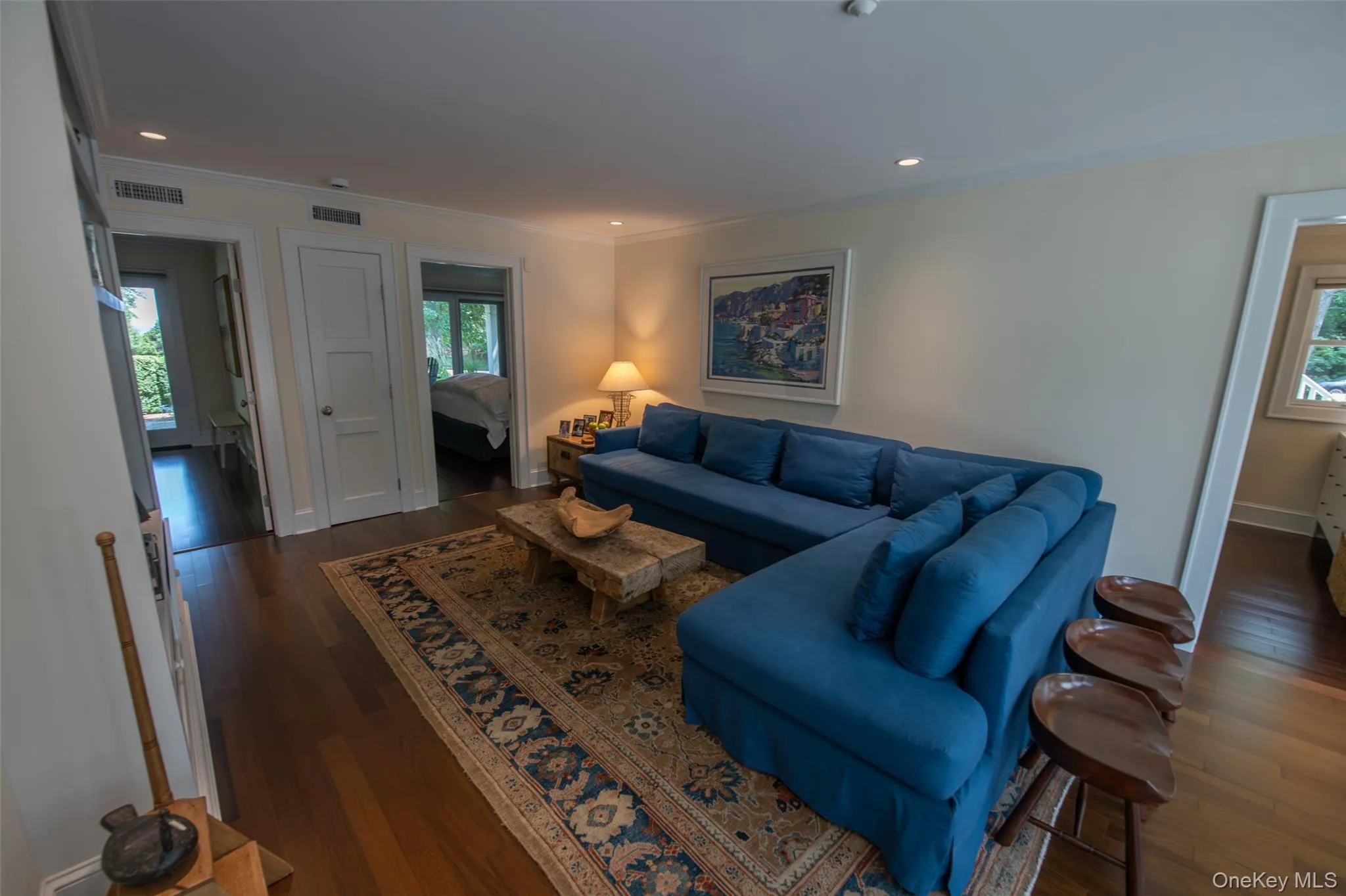 Hardwood flooring extends throughout this space, complemented by recessed lighting and a patterned area rug Hardwood flooring extends throughout this space, complemented by recessed lighting and a patterned area rug