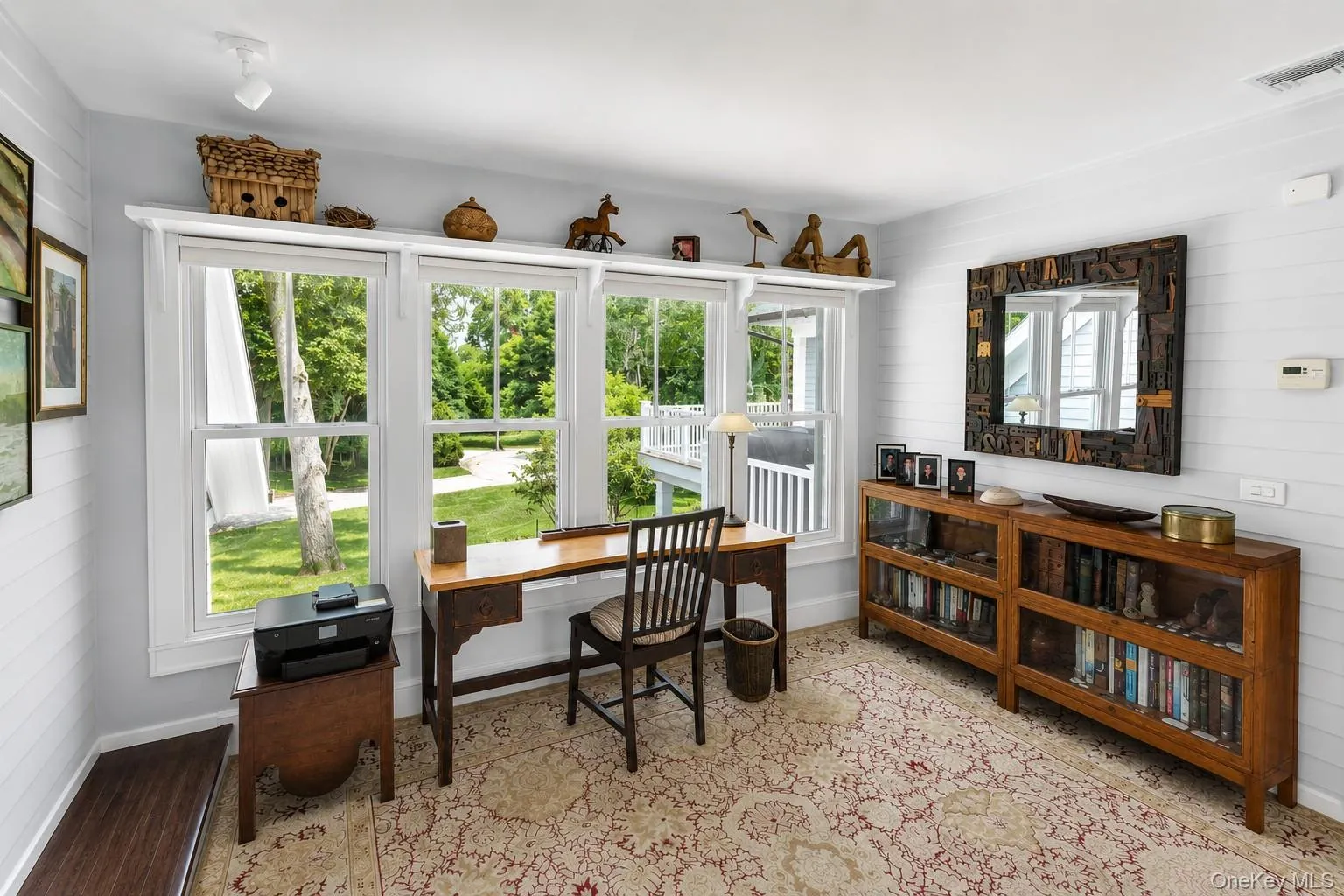 Room featuring a series of three large windows, textured wall paneling, recessed ceiling lighting, and patterned area rug Room featuring a series of three large windows, textured wall paneling, recessed ceiling lighting, and patterned area rug