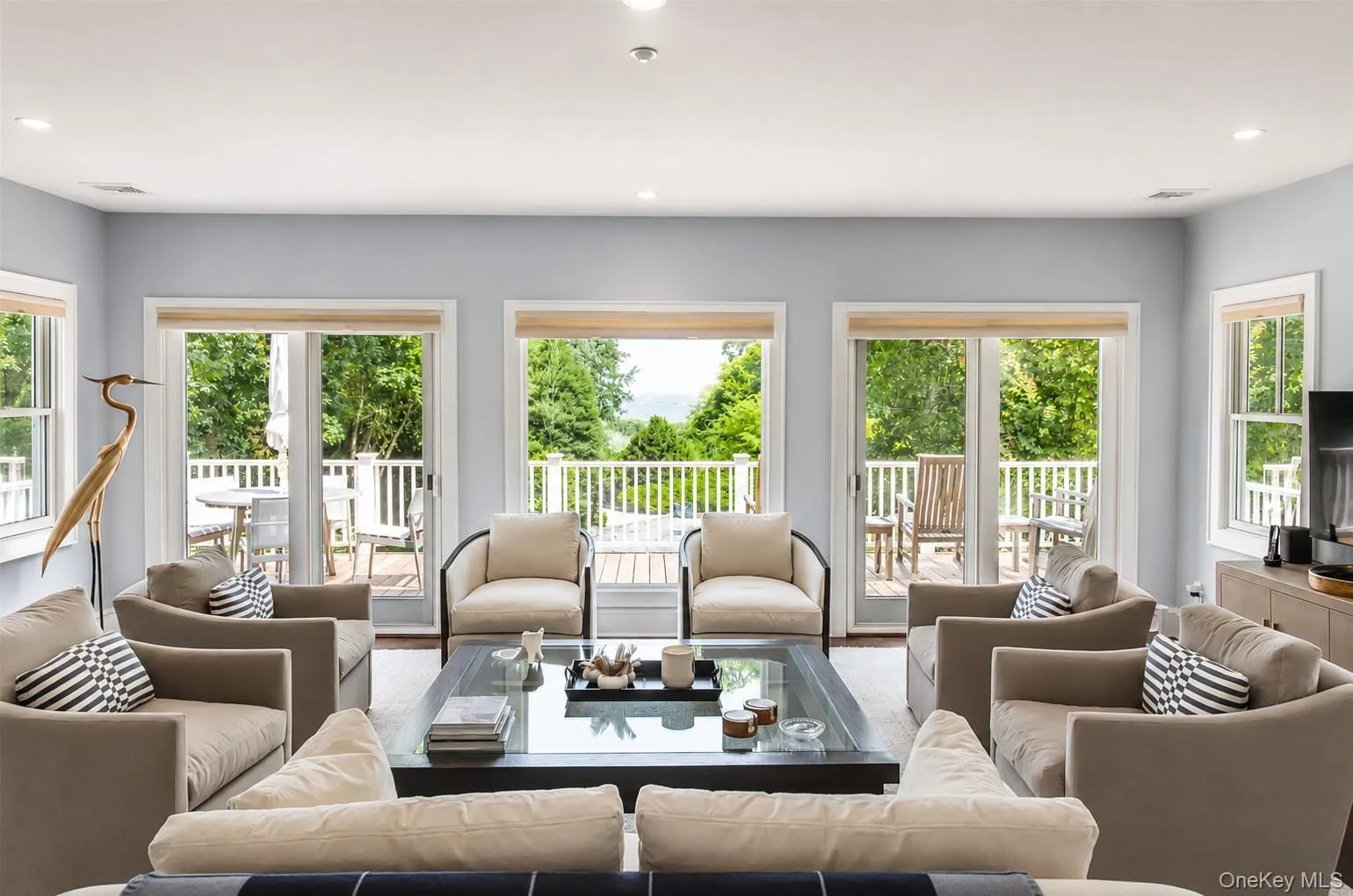 Spacious living area featuring light-toned walls, recessed lighting, and wood-finish flooring Spacious living area featuring light-toned walls, recessed lighting, and wood-finish flooring