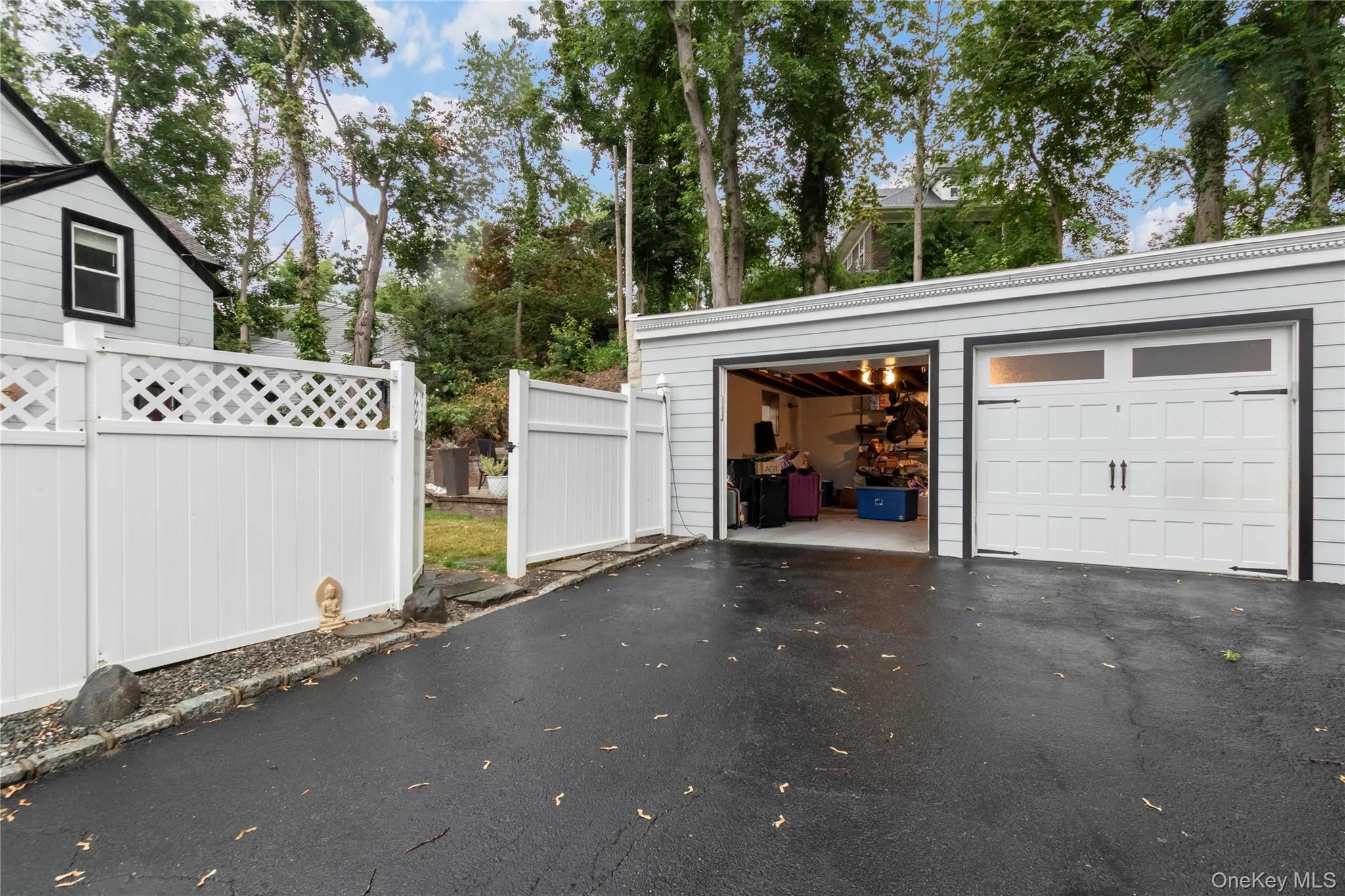 Two-car garage featuring light gray siding and black trim Two-car garage featuring light gray siding and black trim