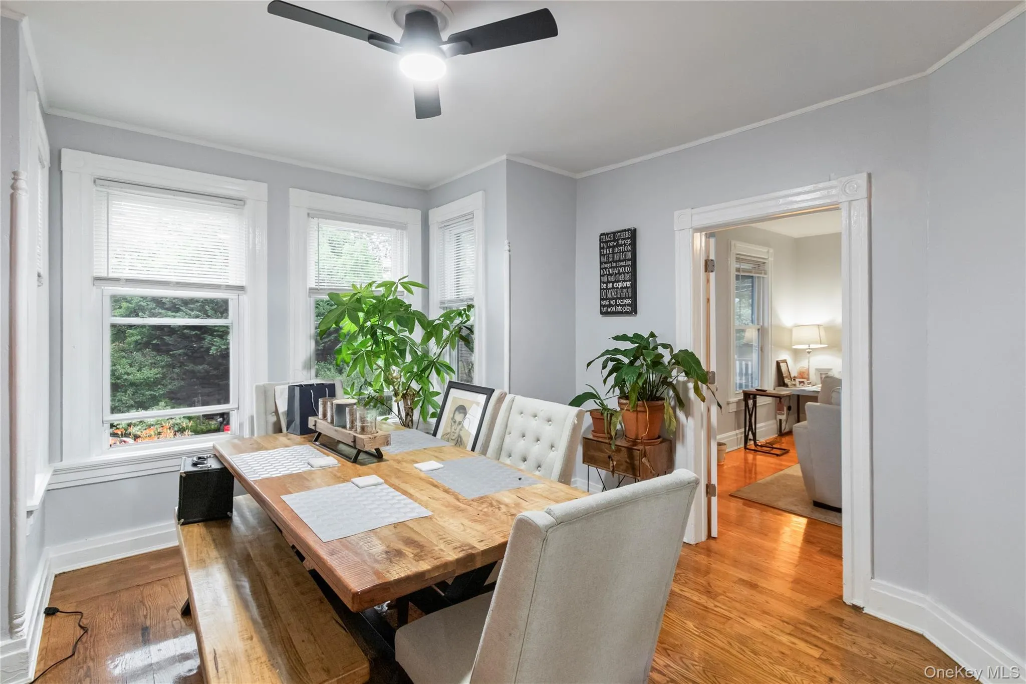 Dining area featuring wood-finish flooring, light gray wall paint, and white trim molding Dining area featuring wood-finish flooring, light gray wall paint, and white trim molding