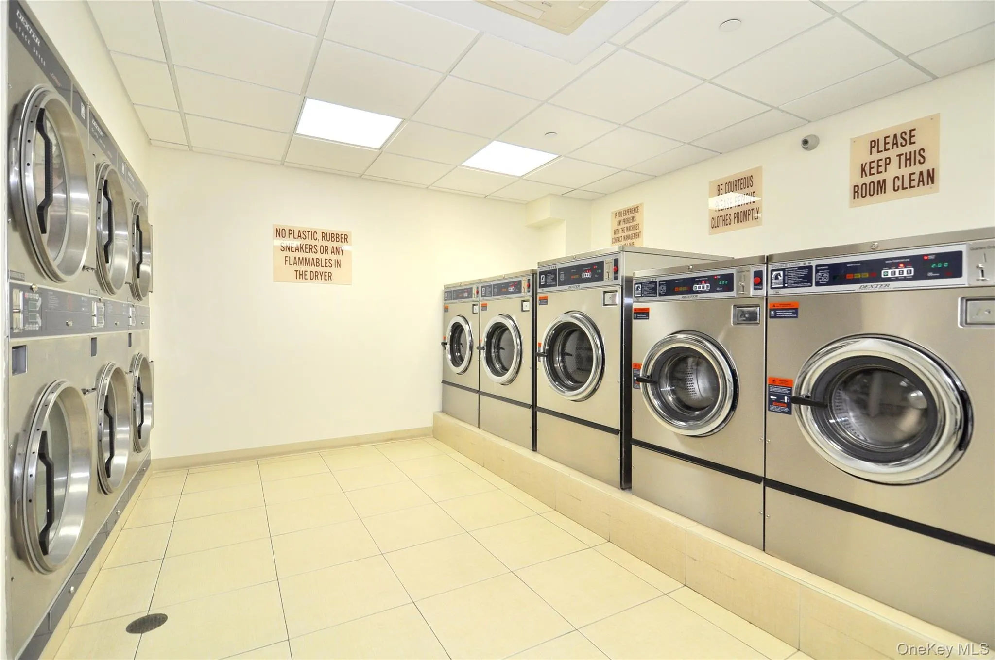 Community laundry room featuring multiple commercial-grade washers and dryers Community laundry room featuring multiple commercial-grade washers and dryers