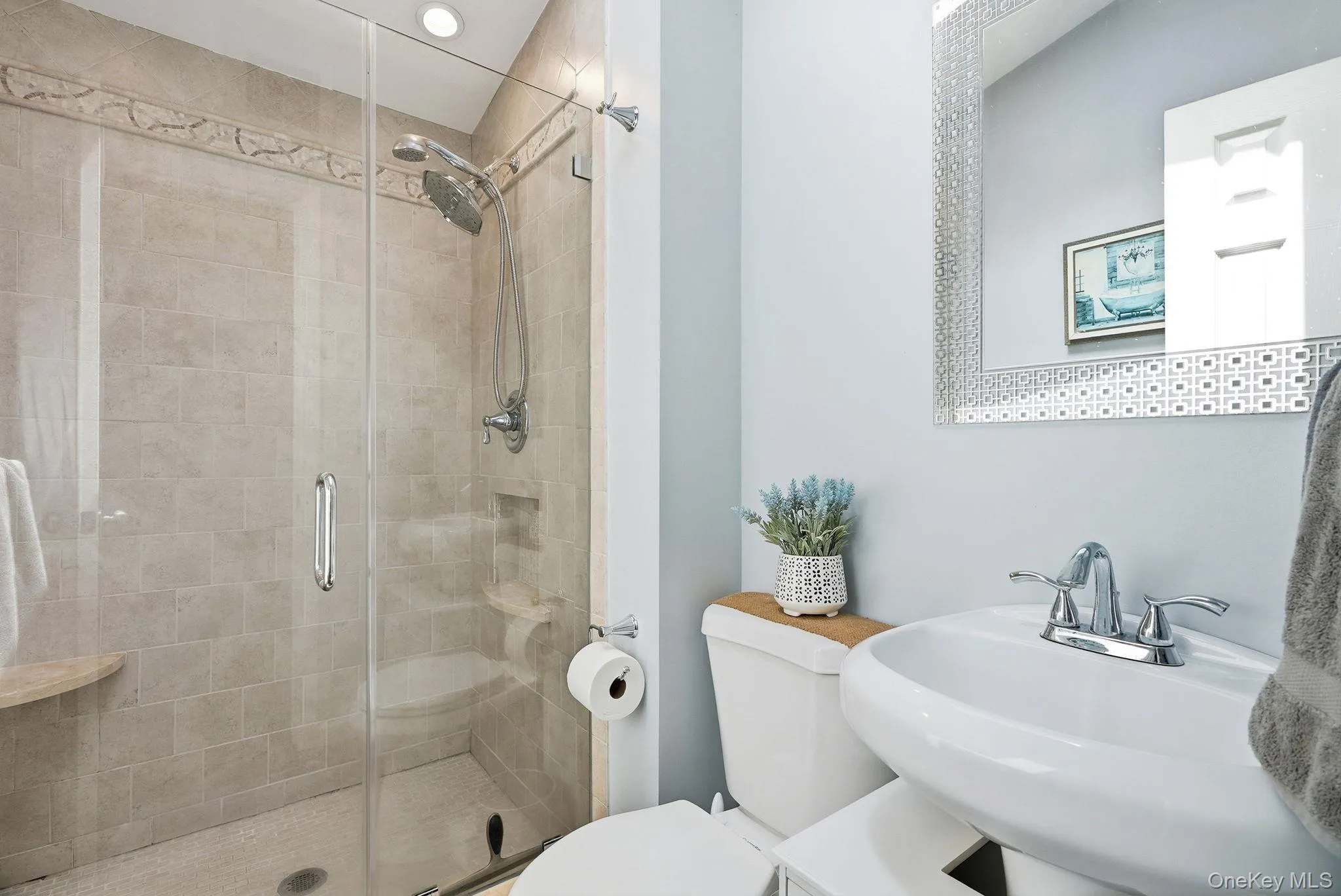 Bathroom featuring a glass-enclosed shower with tile surround, a built-in shower niche, and a corner shelf Bathroom featuring a glass-enclosed shower with tile surround, a built-in shower niche, and a corner shelf