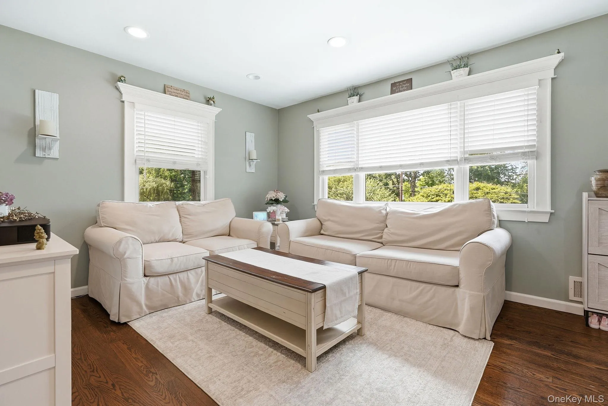 Living area featuring rich wood-finish flooring, recessed lighting, and elegant crown molding Living area featuring rich wood-finish flooring, recessed lighting, and elegant crown molding