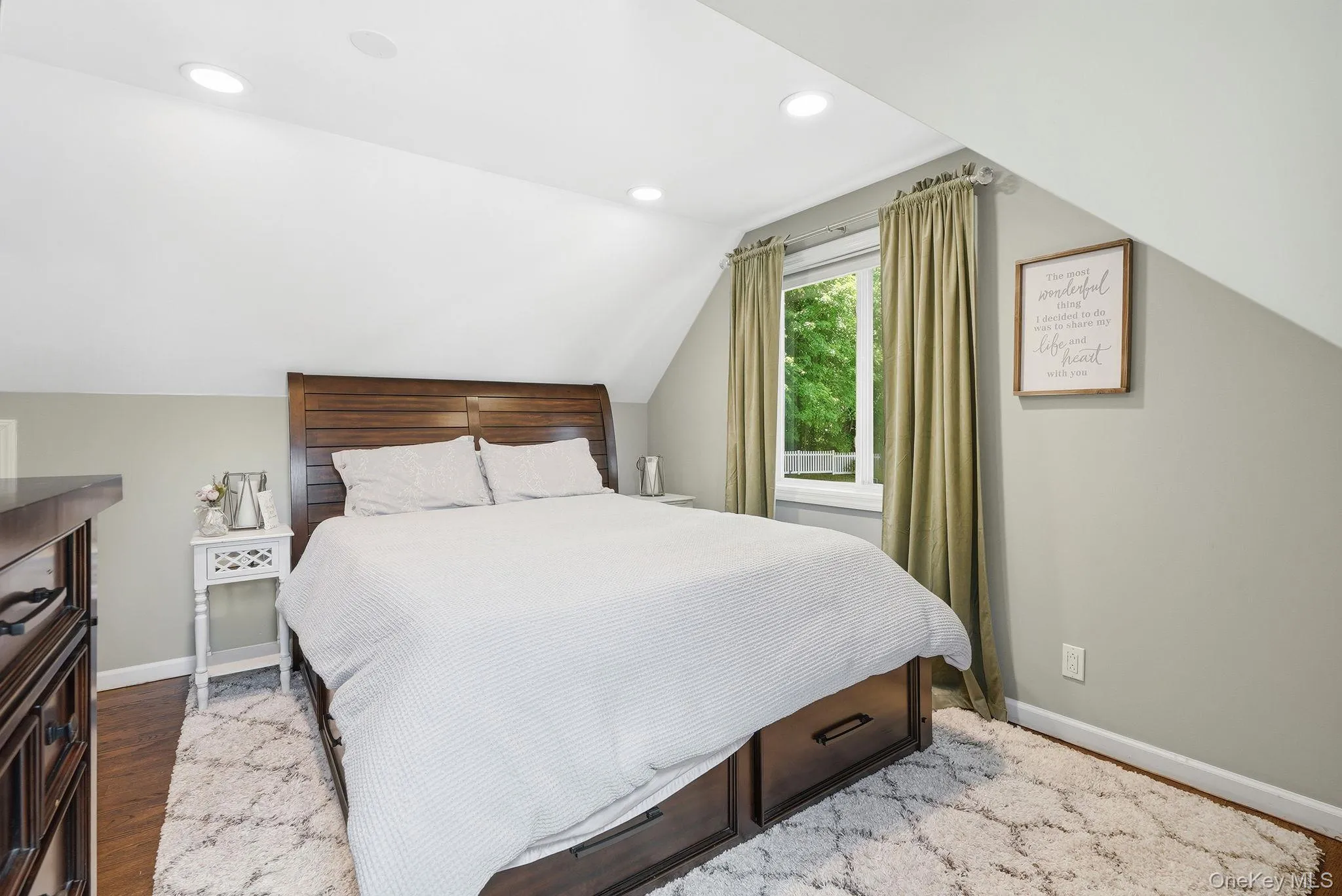 Spacious bedroom featuring an angled ceiling and recessed lighting Spacious bedroom featuring an angled ceiling and recessed lighting