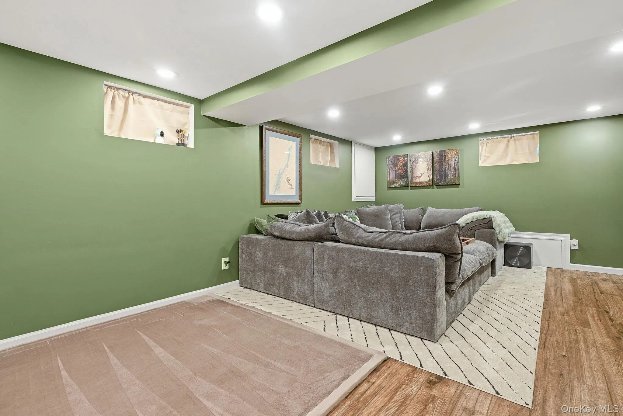 Recreational room featuring recessed lighting, painted walls, and wood-finish flooring Recreational room featuring recessed lighting, painted walls, and wood-finish flooring