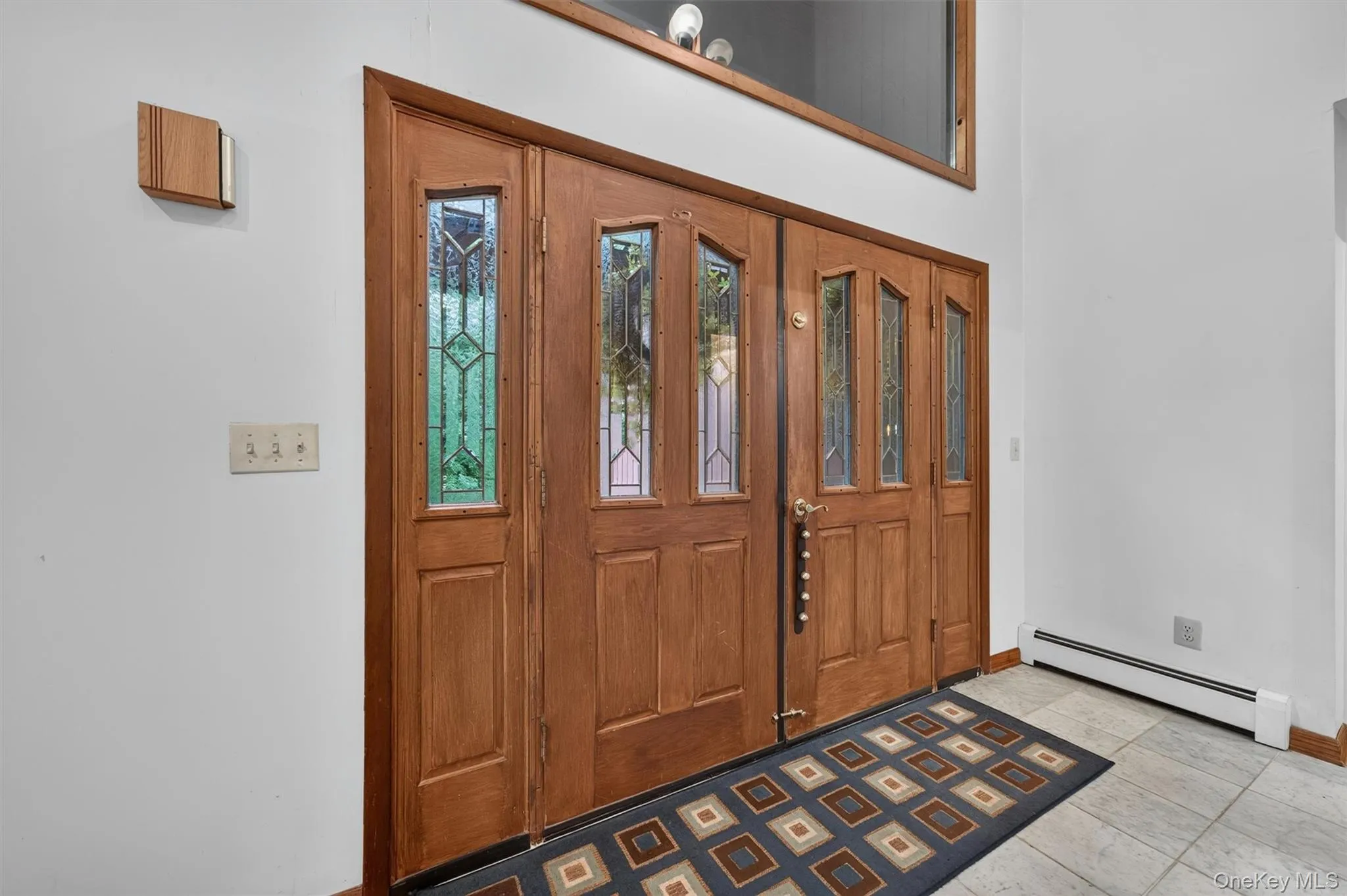 The entrance is impressive with it's high ceilings, double doors and window. The entrance is impressive with it's high ceilings, double doors and window.