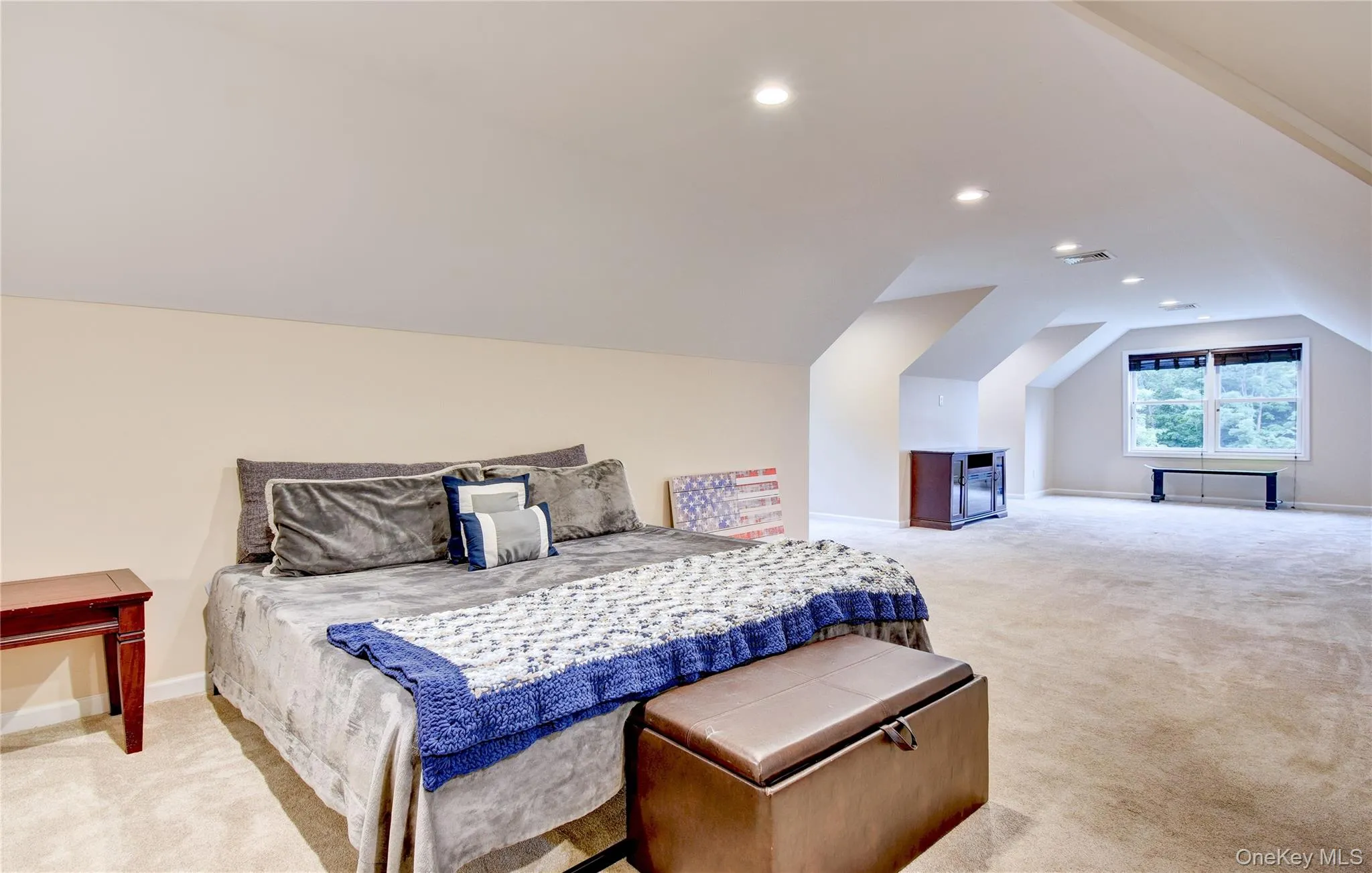 Spacious bonus room featuring sloped ceilings, recessed lighting, neutral-toned carpeting, and a double window Spacious bonus room featuring sloped ceilings, recessed lighting, neutral-toned carpeting, and a double window