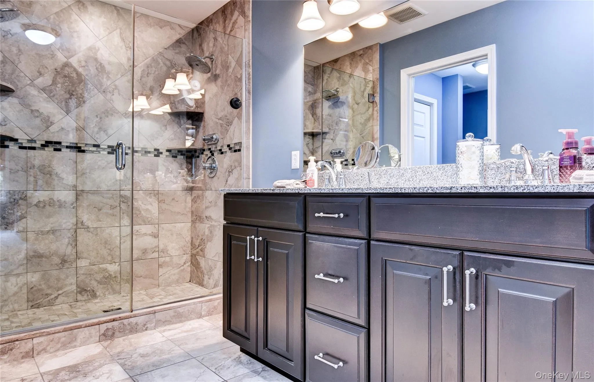 Primary Bathroom featuring a dual vanity with dark wood cabinetry, granite countertop, and two undermount sinks Primary Bathroom featuring a dual vanity with dark wood cabinetry, granite countertop, and two undermount sinks