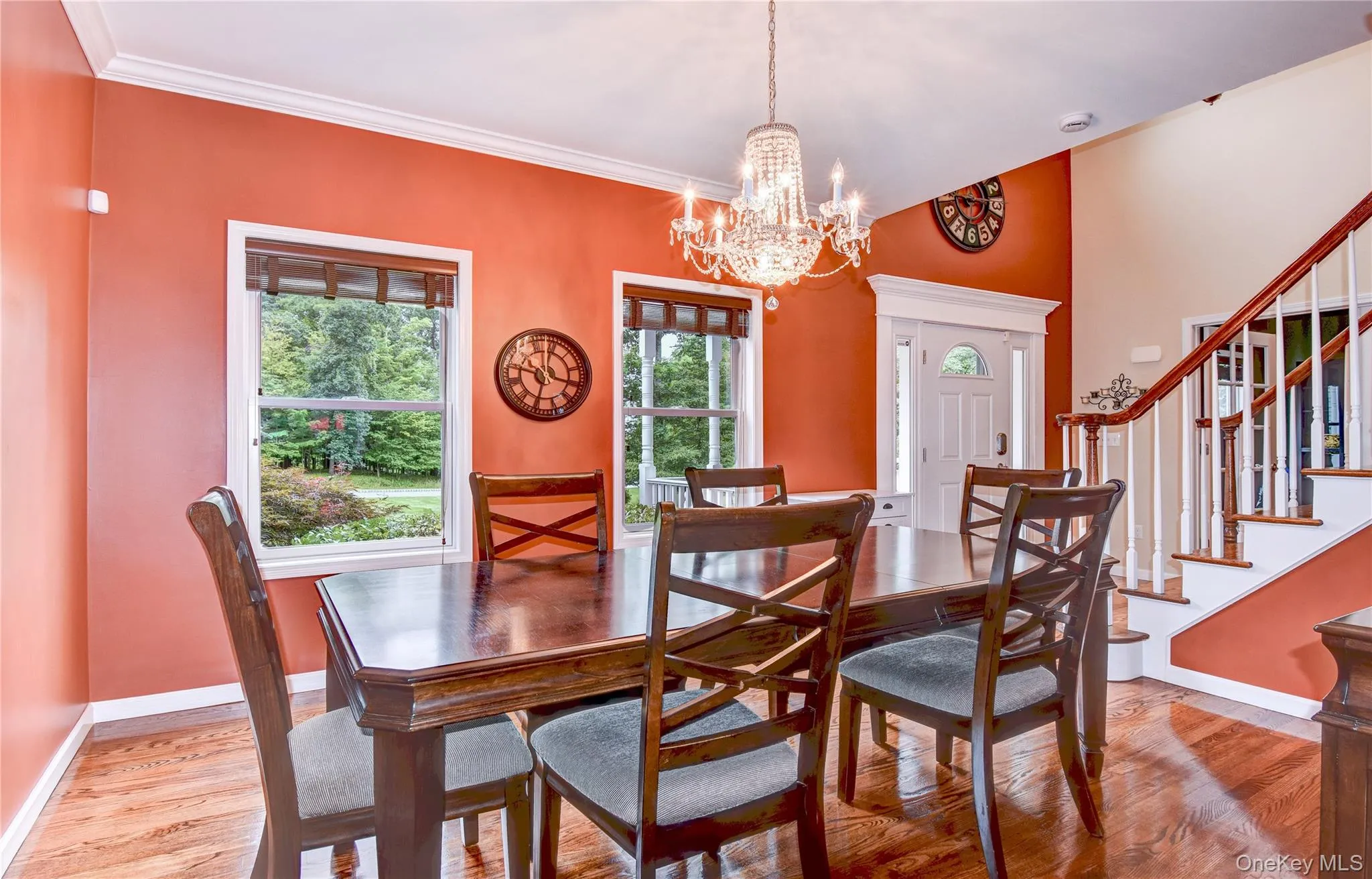 Dining space featuring wood flooring, a crystal chandelier, and two large windows Dining space featuring wood flooring, a crystal chandelier, and two large windows