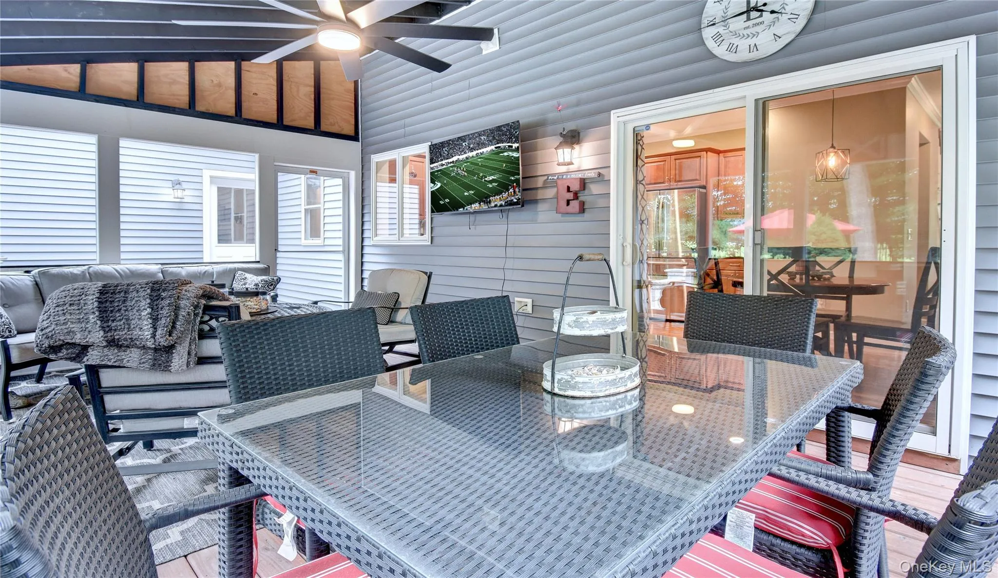 Screened porch featuring a vaulted ceiling with exposed beams, wood-finish flooring, and a ceiling fan Screened porch featuring a vaulted ceiling with exposed beams, wood-finish flooring, and a ceiling fan