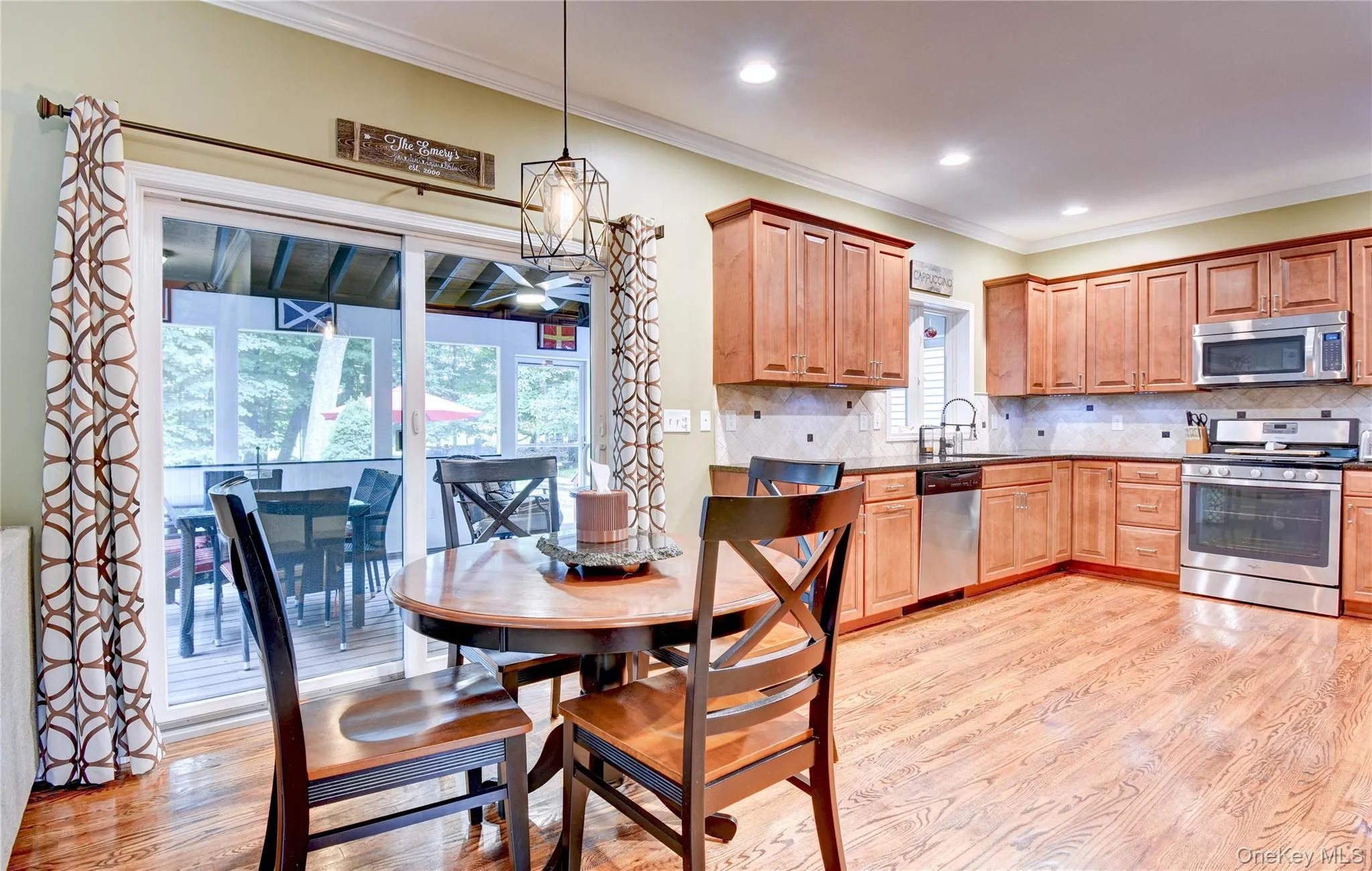 Kitchen with wood flooring, recessed lighting, and a sliding glass door opening to an enclosed porch Kitchen with wood flooring, recessed lighting, and a sliding glass door opening to an enclosed porch