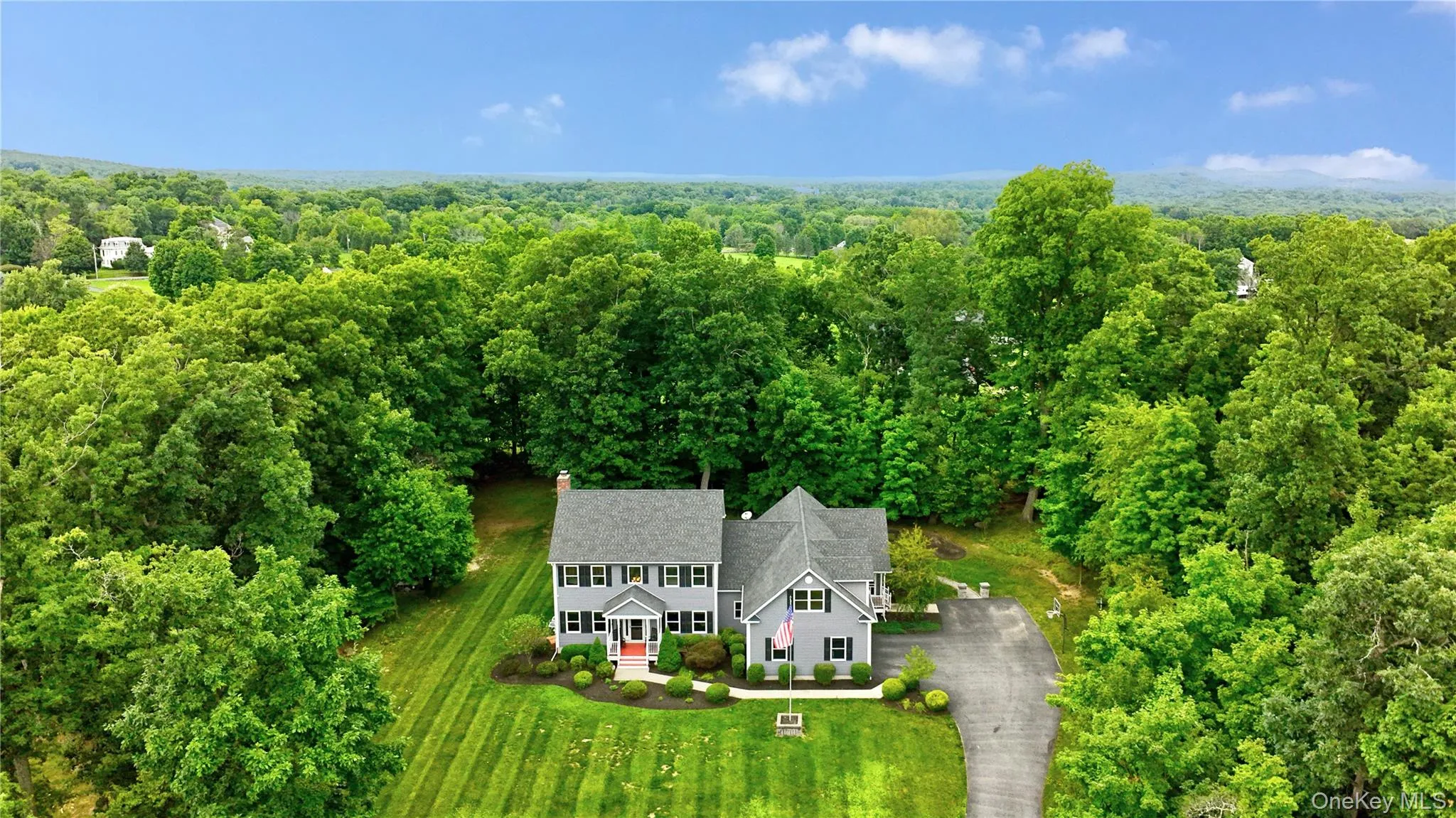 Expansive property featuring a grey siding residence with multiple dormers, black louvered shutters and with legal accessory apartment Expansive property featuring a grey siding residence with multiple dormers, black louvered shutters and with legal accessory apartment
