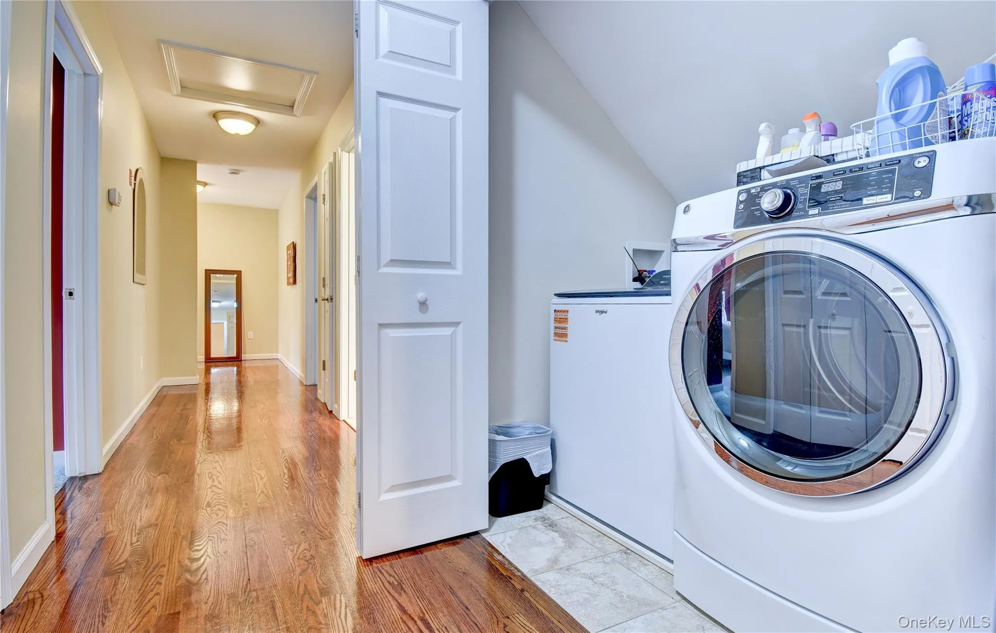 Dedicated laundry area with a front-loading washer and a top-loading appliance, featuring tiled flooring Dedicated laundry area with a front-loading washer and a top-loading appliance, featuring tiled flooring