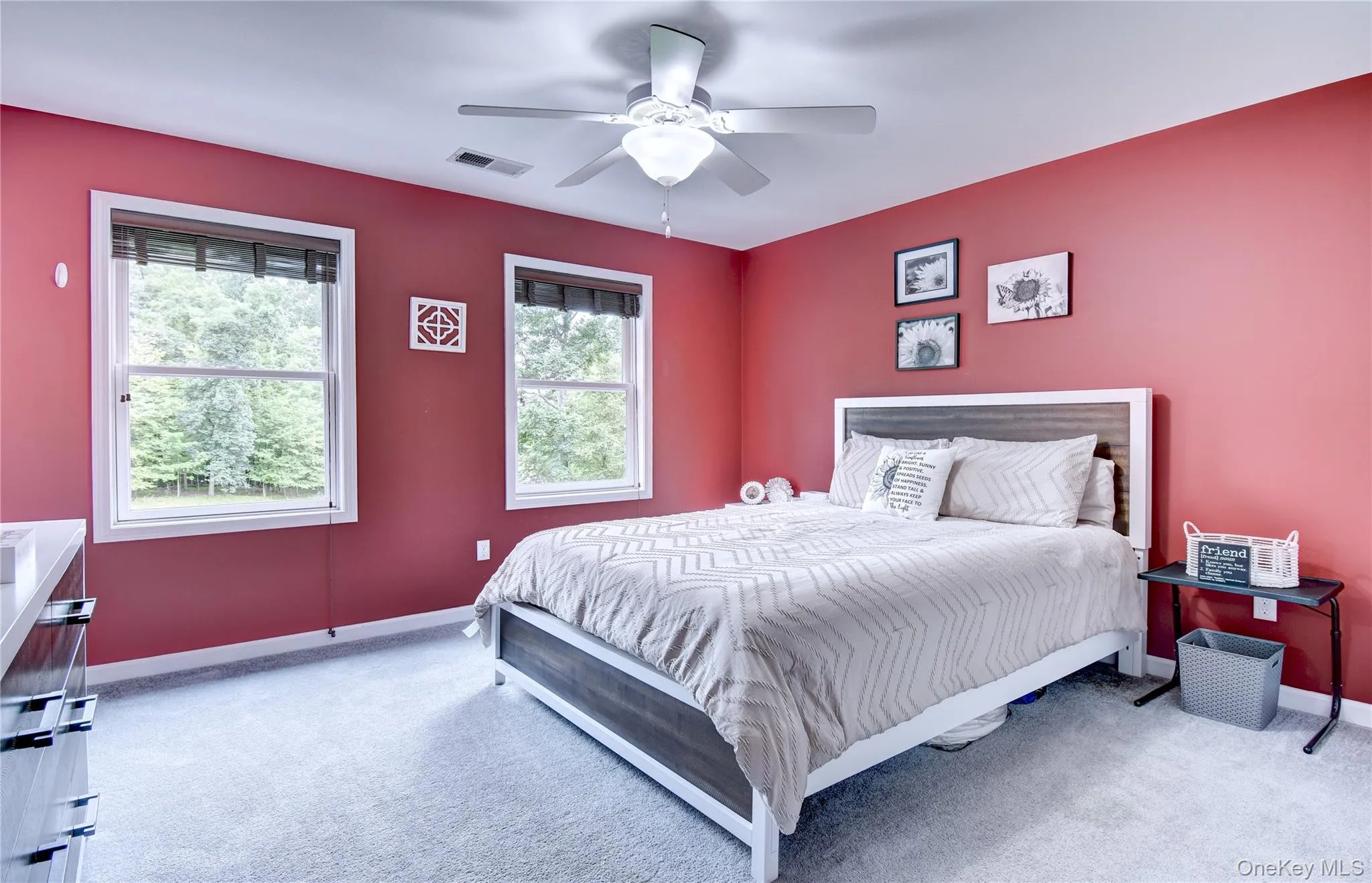 Spacious bedroom featuring neutral-toned carpet, a ceiling fan with integrated lighting Spacious bedroom featuring neutral-toned carpet, a ceiling fan with integrated lighting