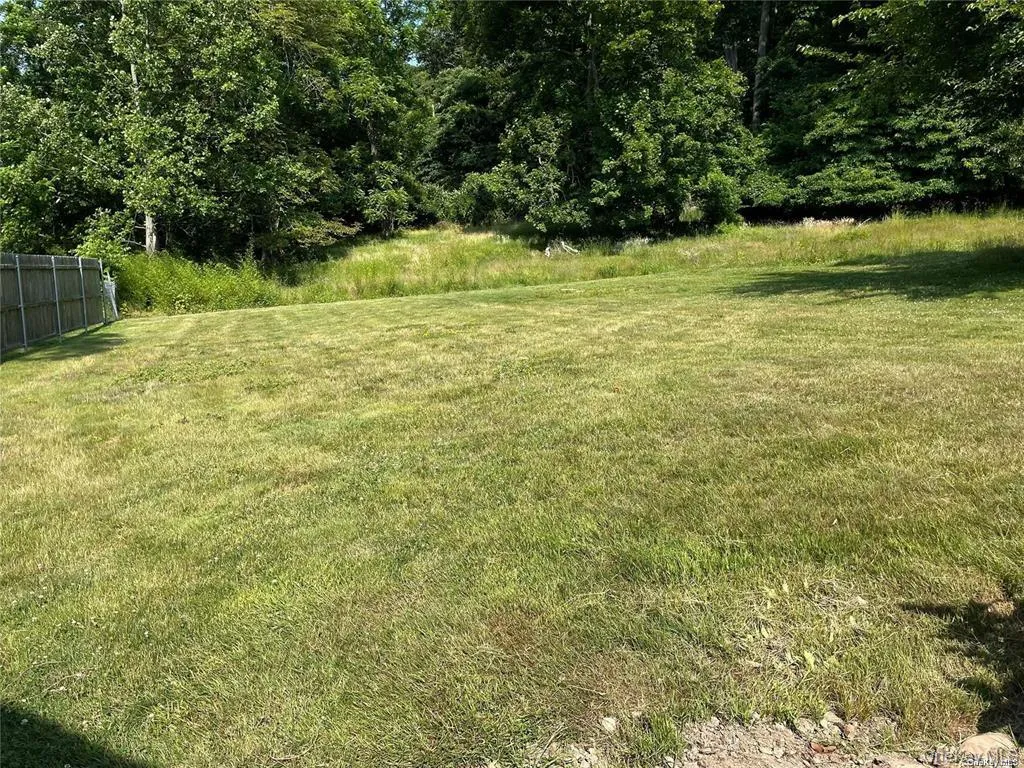 Expansive green lawn with a partial privacy fence Expansive green lawn with a partial privacy fence