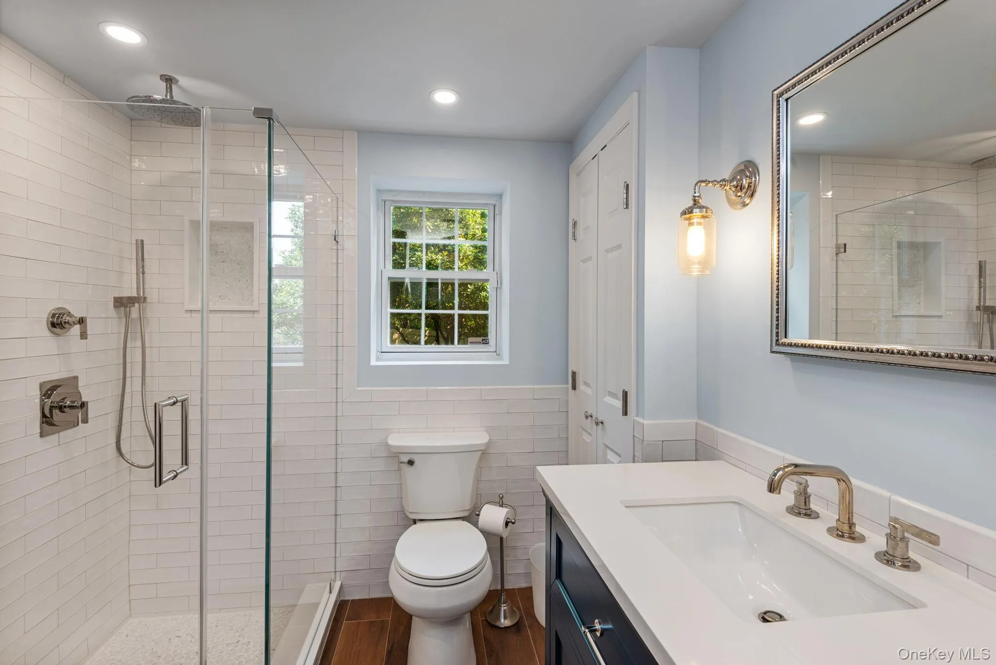 Bathroom with glass-enclosed shower with subway tile surround and rain shower head Bathroom with glass-enclosed shower with subway tile surround and rain shower head