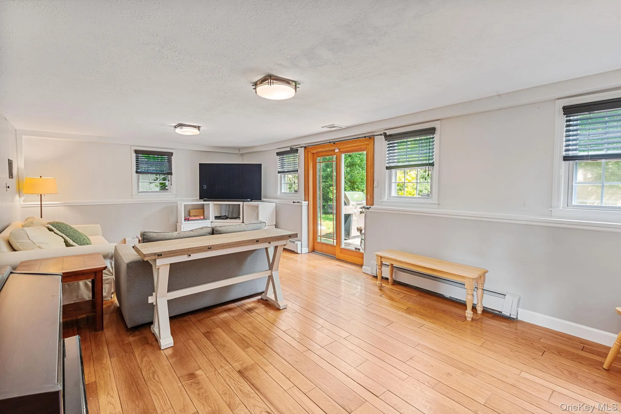 Lower level with hardwood flooring throughout featuring recessed lighting and a double-door exterior entry onto backyard deck Lower level with hardwood flooring throughout featuring recessed lighting and a double-door exterior entry onto backyard deck