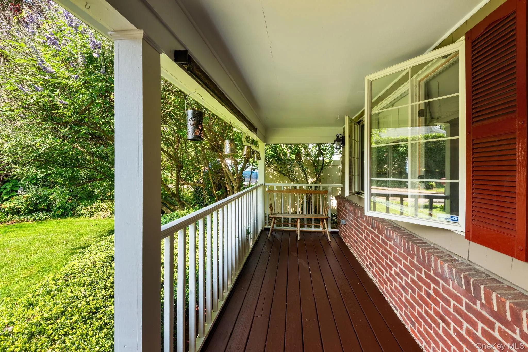 Shingle-sided residence featuring a covered porch with white railings Shingle-sided residence featuring a covered porch with white railings