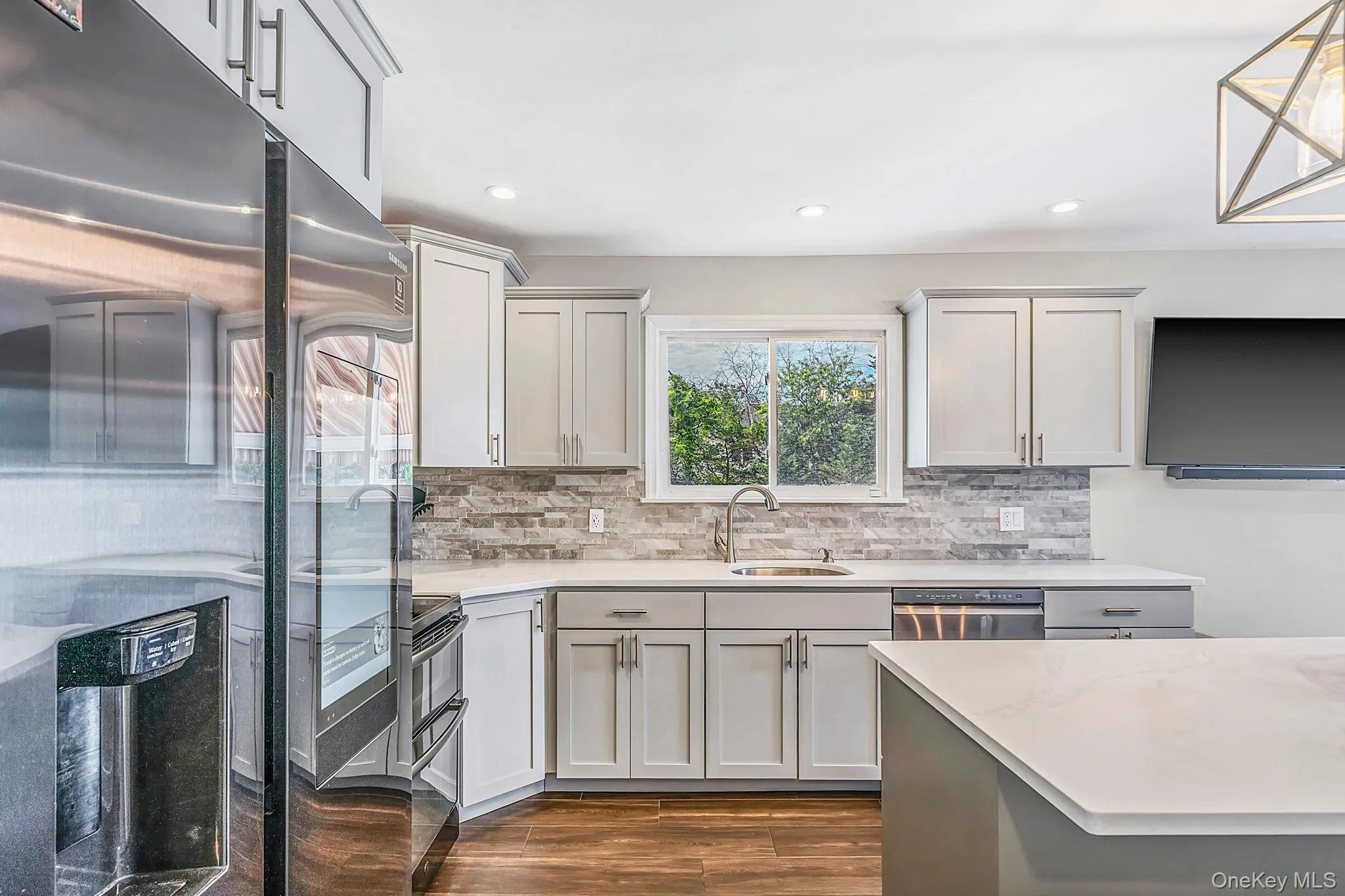 Modern stainless steel appliances, Samsung refrigerator w/smart board and large kitchen island with built-in wine/beverage cooler. Modern stainless steel appliances, Samsung refrigerator w/smart board and large kitchen island with built-in wine/beverage cooler.