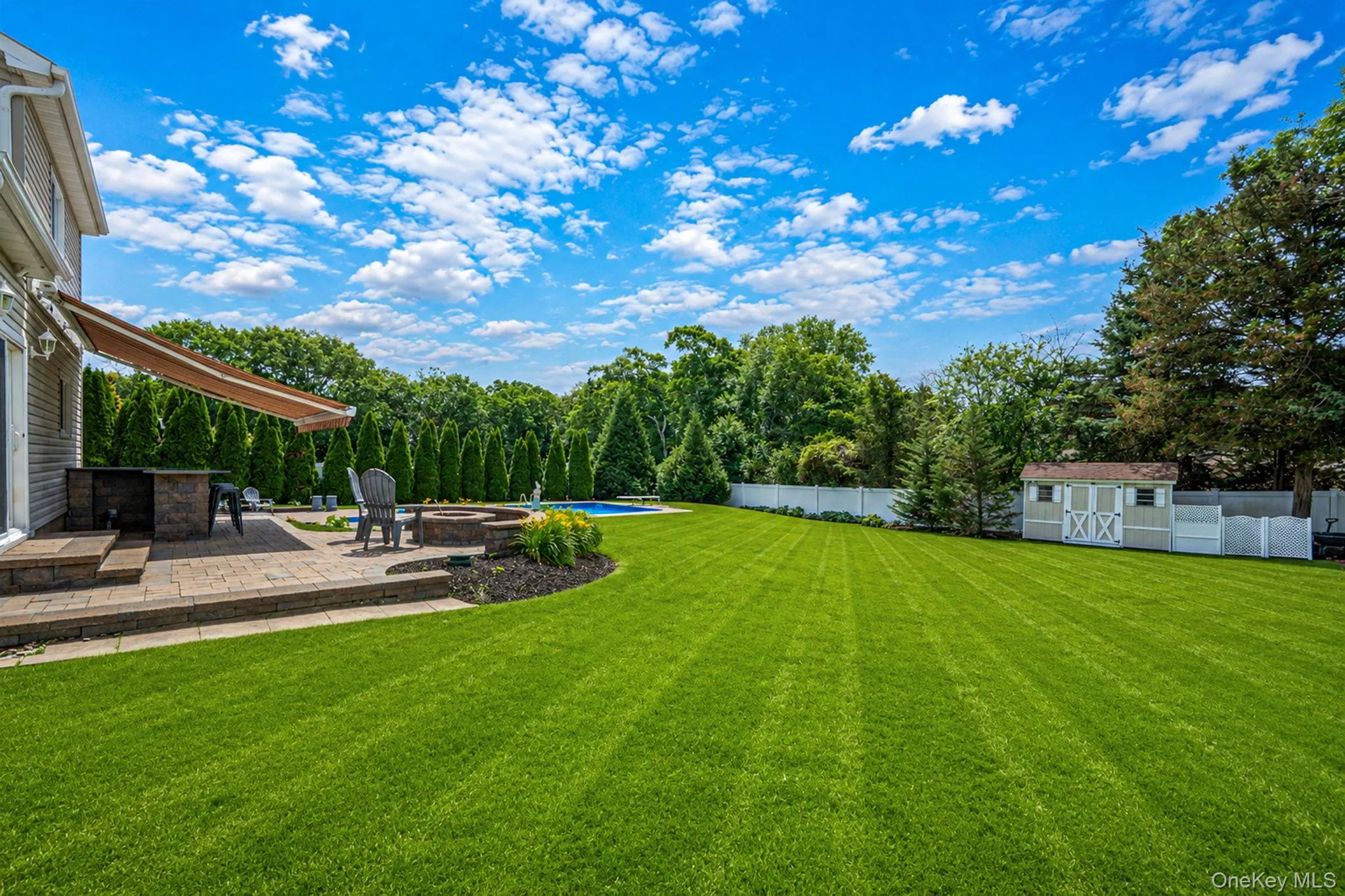 Beautifully maintained backyard featuring multiple level patios, built-in fire pit, and an outdoor granite bar grilling area with an auto retractable sun awning. Picture perfect! 100x168 Lot Beautifully maintained backyard featuring multiple level patios, built-in fire pit, and an outdoor granite bar grilling area with an auto retractable sun awning. Picture perfect! 100x168 Lot