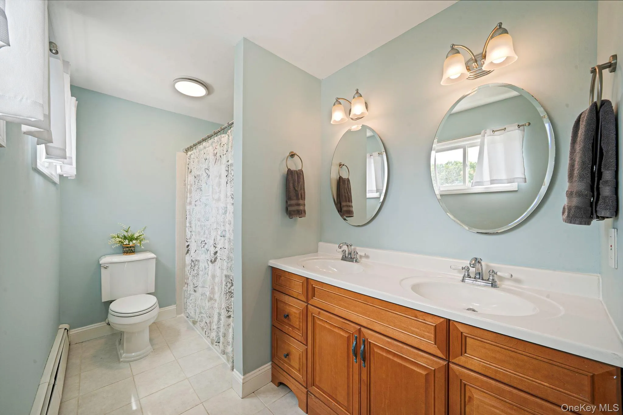 Spacious 2nd floor bathroom featuring a double vanity with oak cabinetry, two undermount sinks, and a spacious porcelain countertop. Spacious 2nd floor bathroom featuring a double vanity with oak cabinetry, two undermount sinks, and a spacious porcelain countertop.