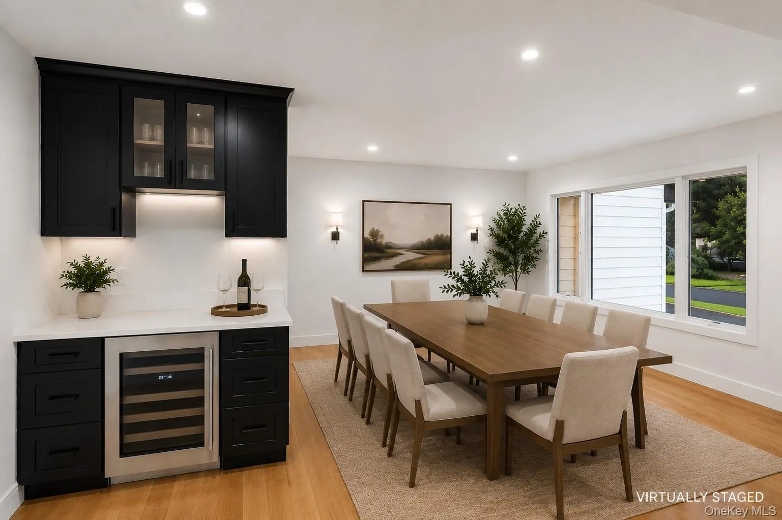 Integrated wet bar featuring black cabinetry, glass-front upper cabinets, and a built-in wine refrigerator. Virtually Staged. Integrated wet bar featuring black cabinetry, glass-front upper cabinets, and a built-in wine refrigerator. Virtually Staged.