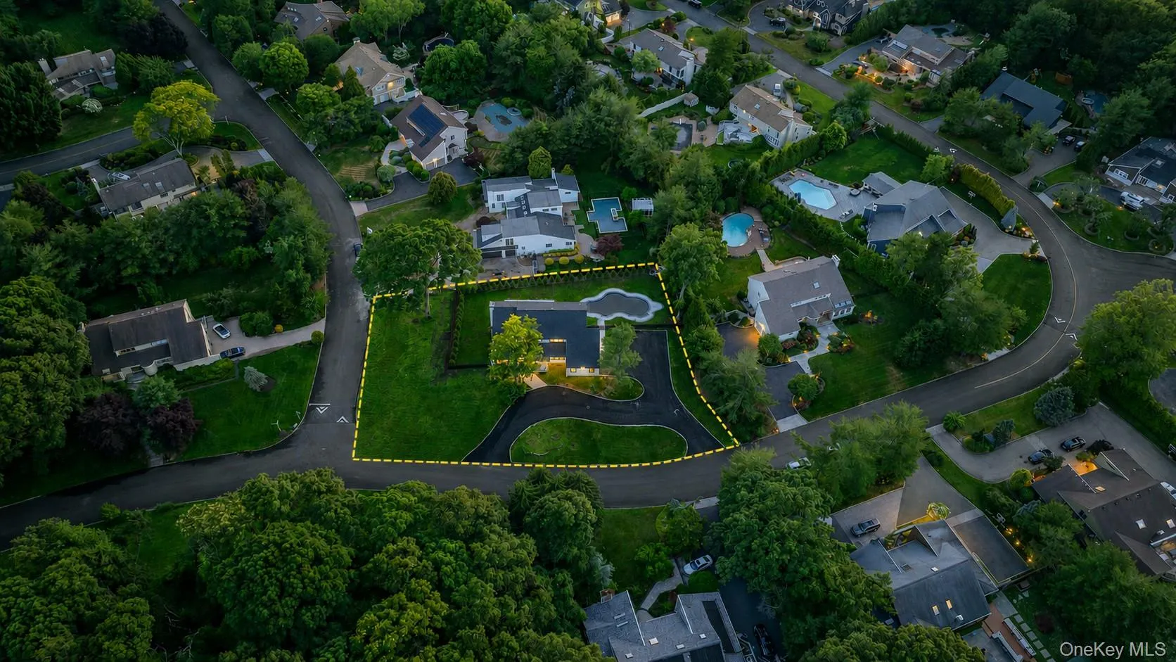 Expansive lot featuring a large lawn, mature trees, and a paved driveway. Yellow lines mark the property line which exceeds past fencing. Expansive lot featuring a large lawn, mature trees, and a paved driveway. Yellow lines mark the property line which exceeds past fencing.